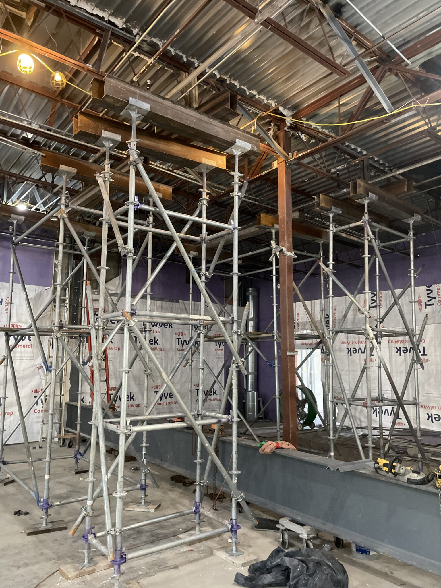 Construction site with scaffolding and metal framework inside a building under renovation