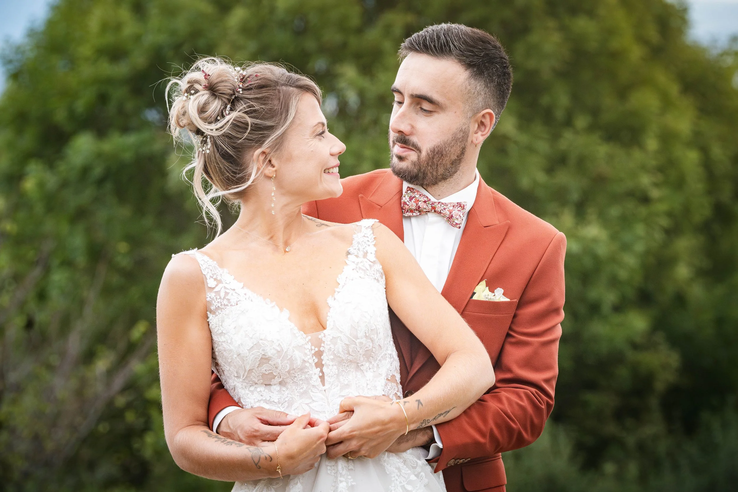Le marié enlace la mariée dans un jardin