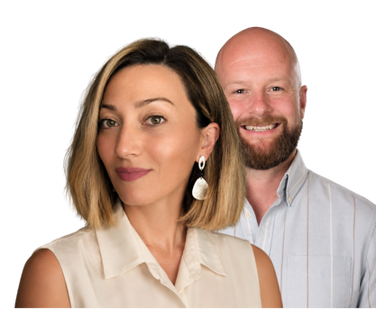 A woman with shoulder-length brown hair and a man with a shaved head and beard smiling, both wearing light-colored clothing, against a black background.