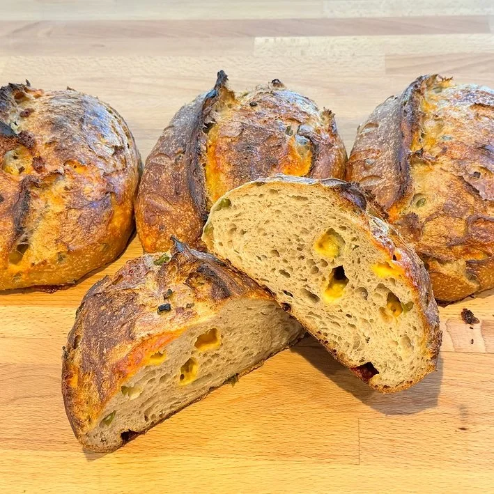  Jalapeño Cheddar Sourdough  Jalapeño Cheddar Sourdough is bold, flavorful, and irresistibly satisfying. Made with fresh, organic jalapeños and sharp cheddar cheese folded into a naturally leavened dough, this loaf strikes the perfect balance between