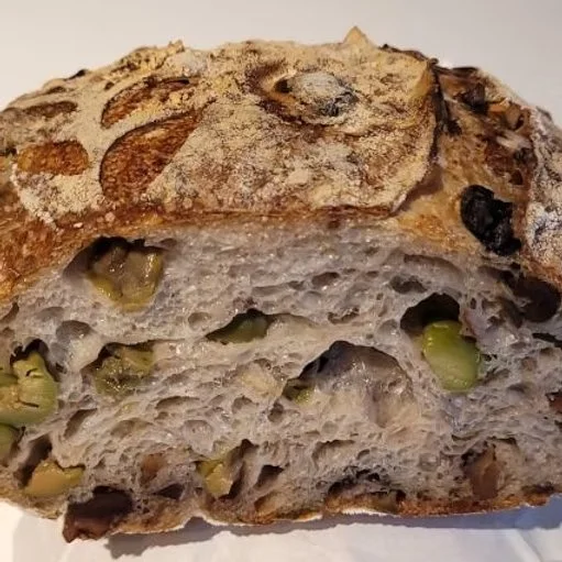  Green Olive and Walnut Sourdough  Green Olive & Walnut Sourdough is a beautifully balanced loaf that combines the buttery richness of Castelvetrano olives with the earthy crunch of chopped organic walnuts. Naturally leavened and slow-fermented for c
