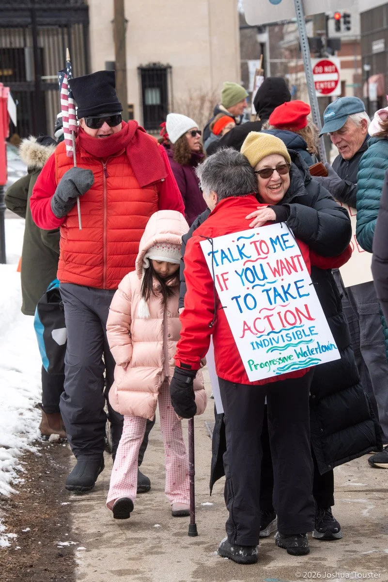 two people hugging at a protest event