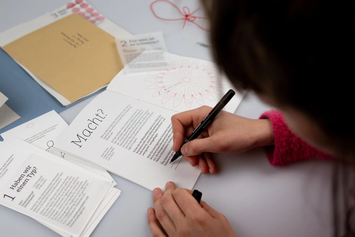 Person filling out a booklet with the title reading "power"