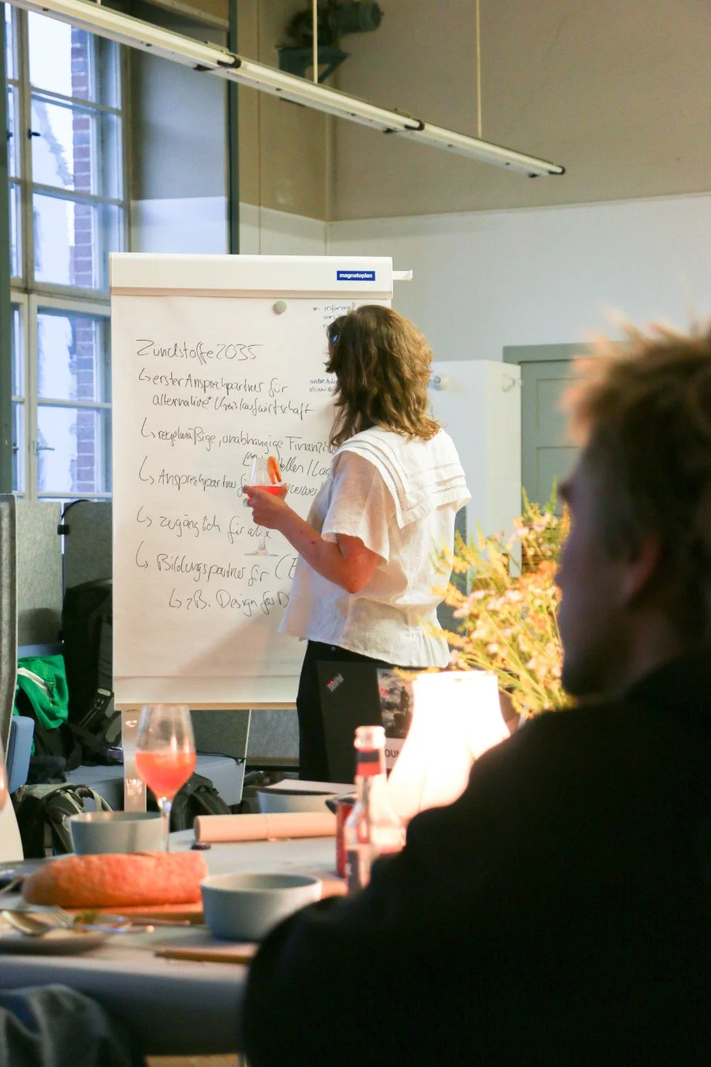 Person writing on a flipchart named "Zündstoffe 2035"