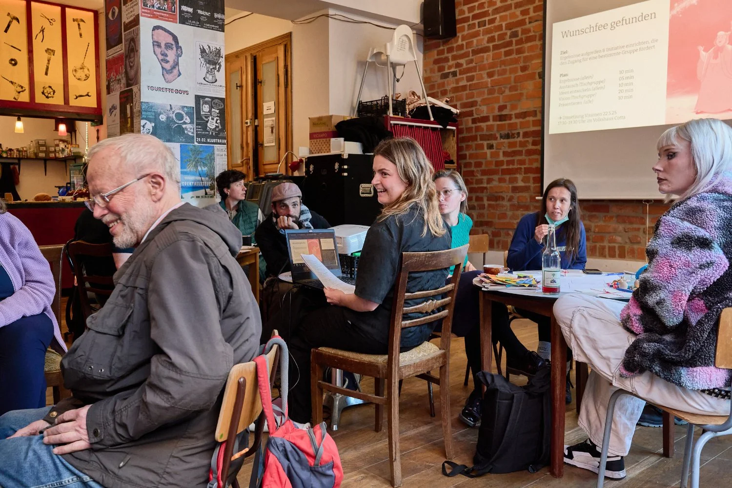 People in groups listening to agenda presentation and laughing