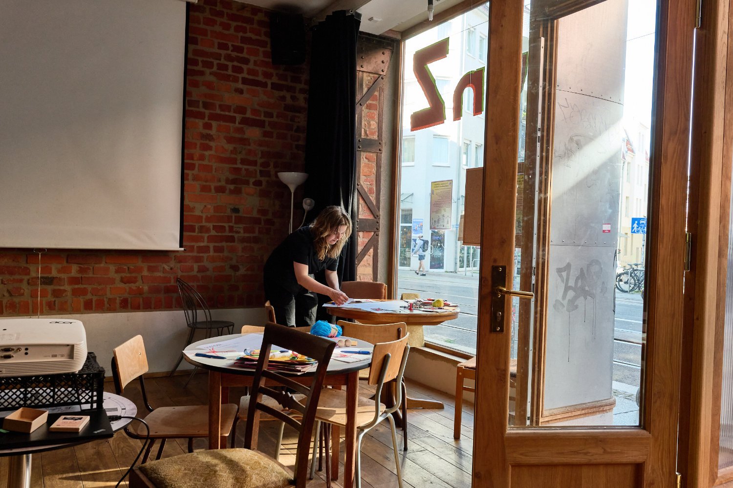 Person distributing diy material on tables in empty room
