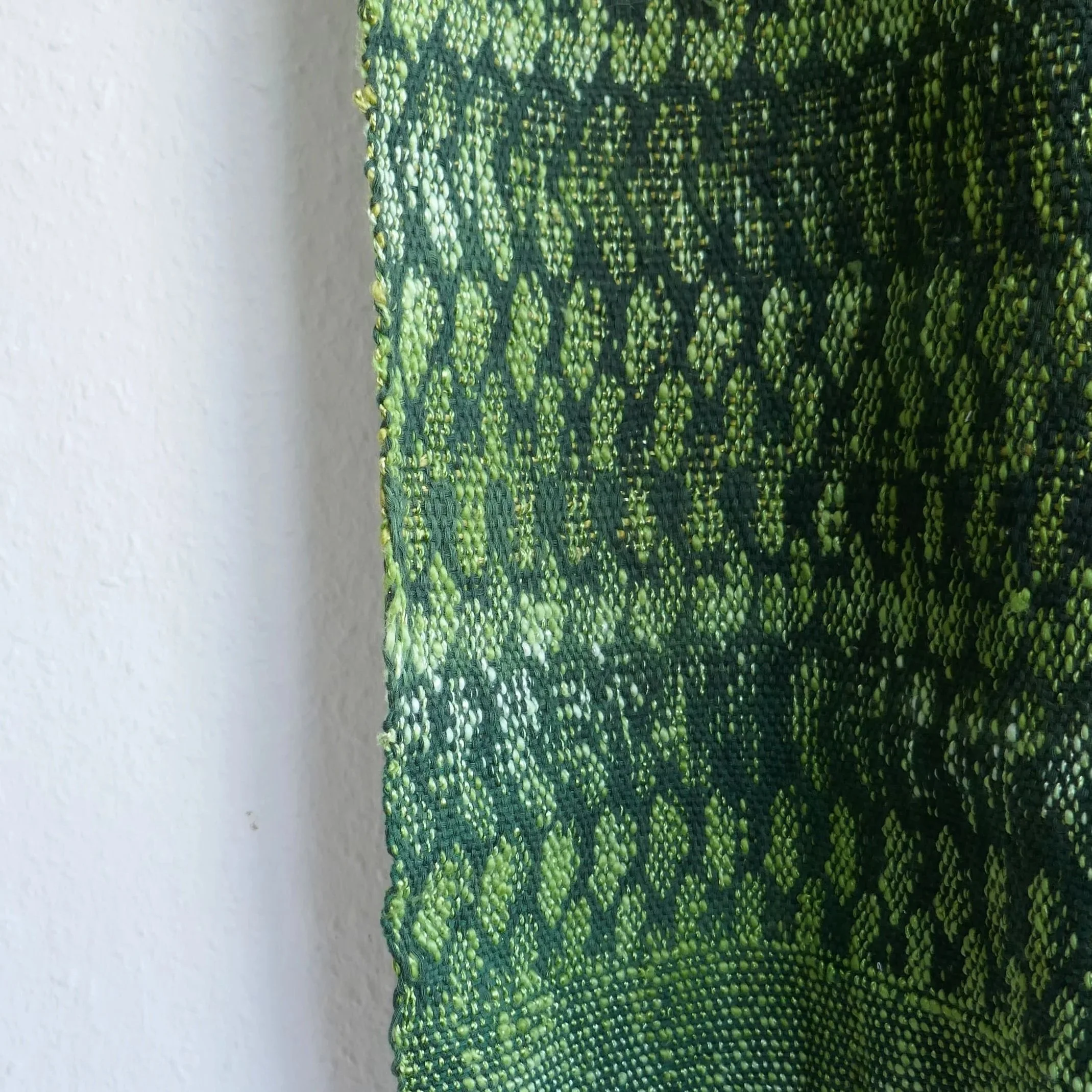 Nahaufnahme eines grünen und gelben gestrickten oder gewebten Textilmusters