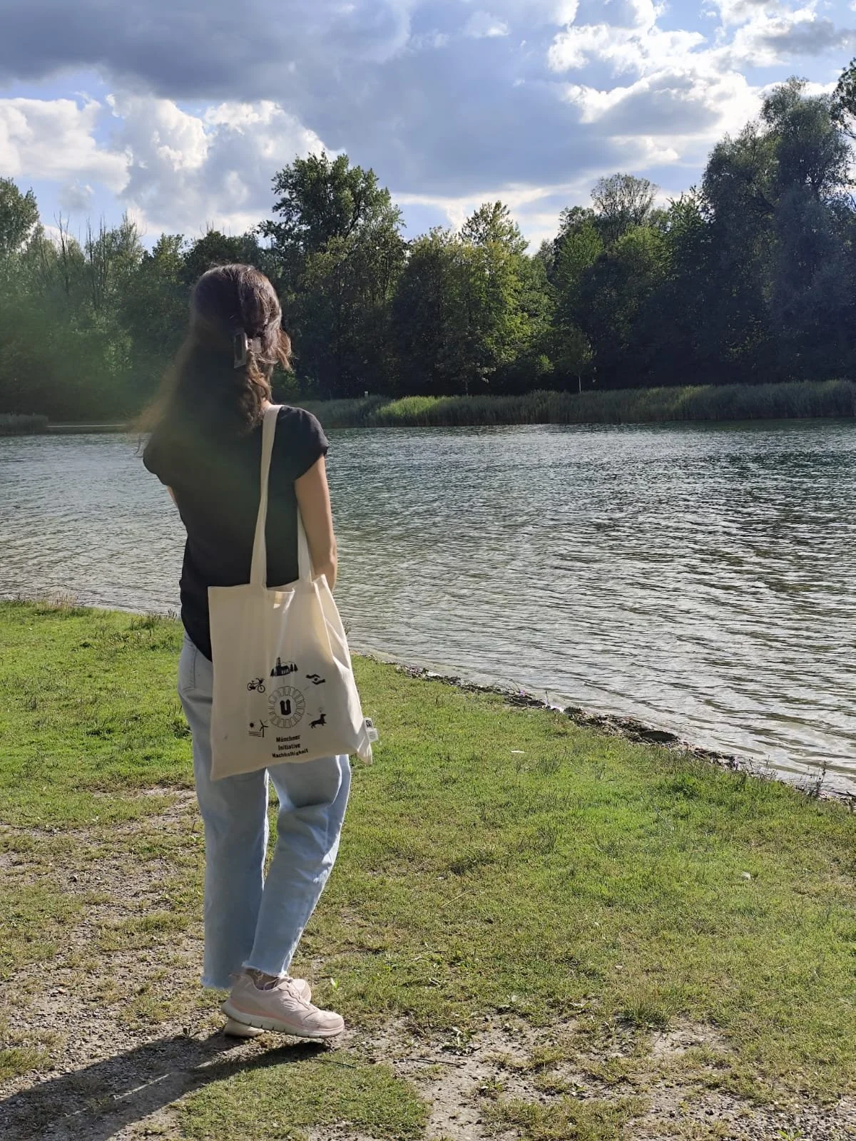Foto von Stoff beutel mit print. Wird von einer Frau getragen. Sie befinden sich am Rand eines Sees