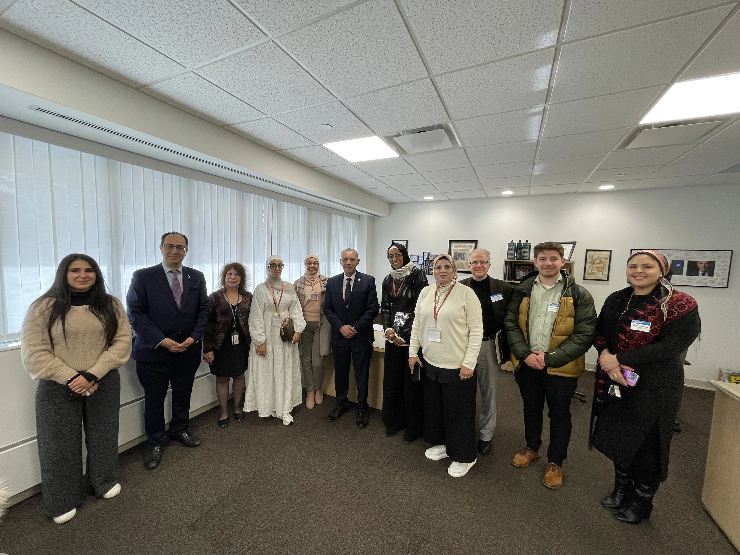Group of diverse people standing in a conference room, smiling for a photo.