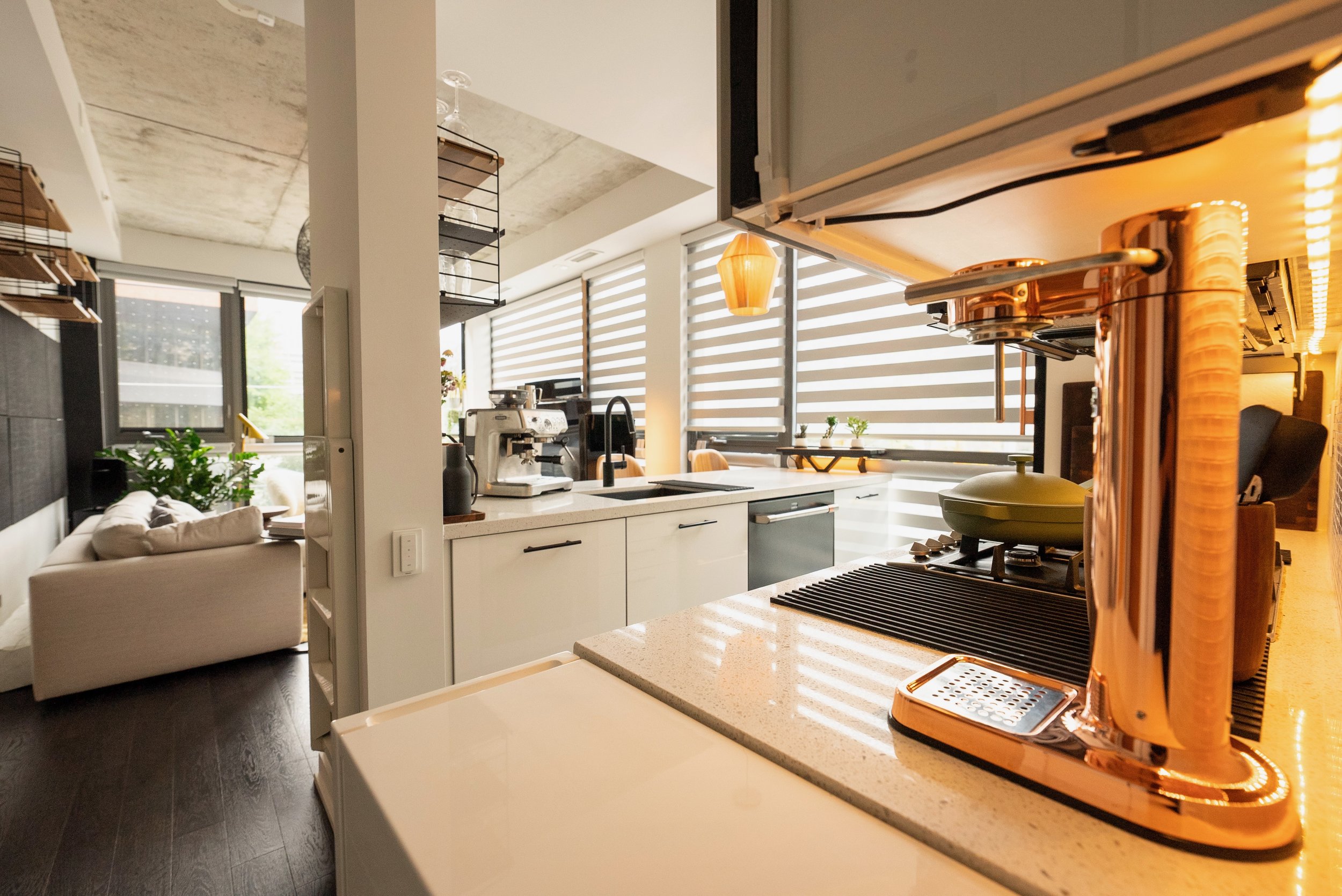 Accents throughout the space were chosen to be cohesive but also add variety. A built in ladder on the wall makes it easier to reach the tall cabinetry and open shelving throughout the home. 