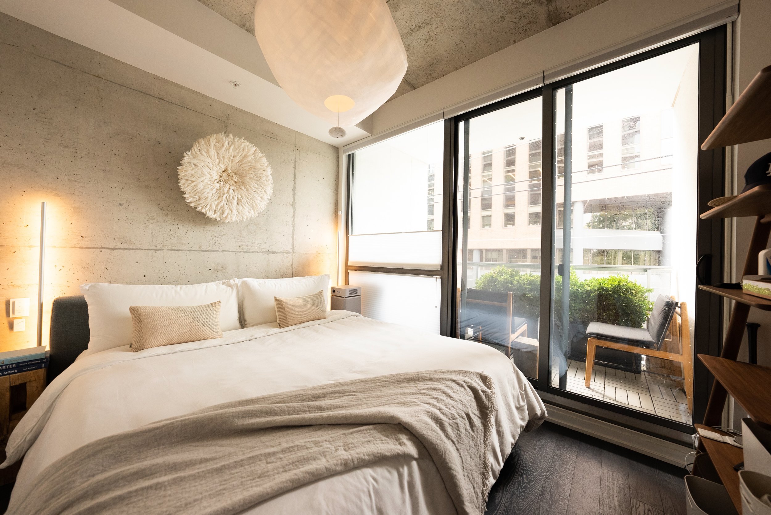 Just off the main living area, the bedroom with it's adjacent balcony is a little oasis. We prioritized a king size bed, black-out blinds that were hidden during the day to allow as much natural light as possible, a boxwood hedge to break up the conc