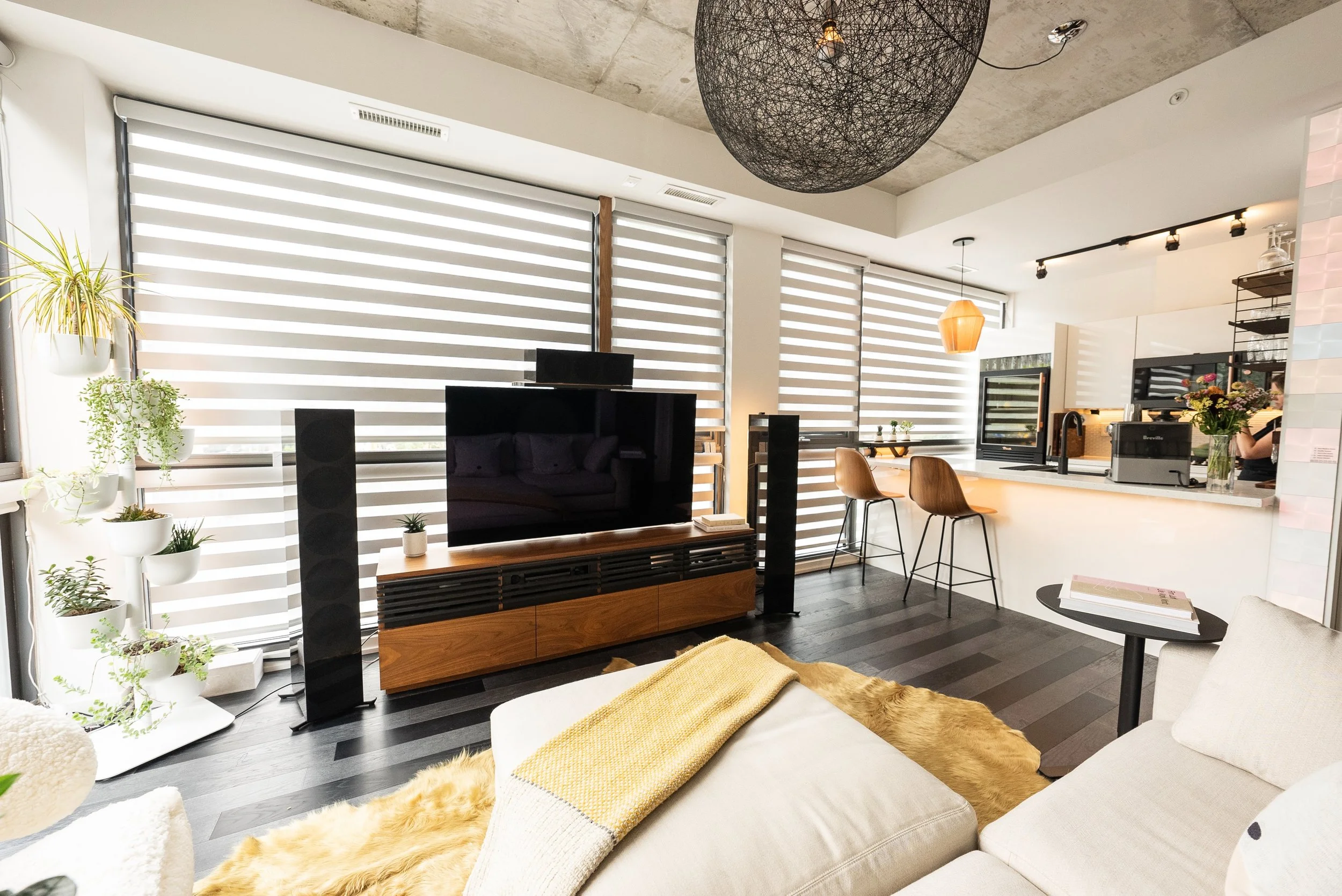 A wall was torn down to create an open concept living, eating and cooking space. This second floor south-west facing condo required window treatments that allowed for not only privacy but also temperature control. 