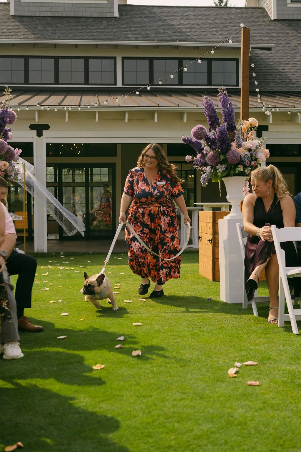 Experienced wedding dog care team posing with dog walking down the aisle during couples wedding ceremony.