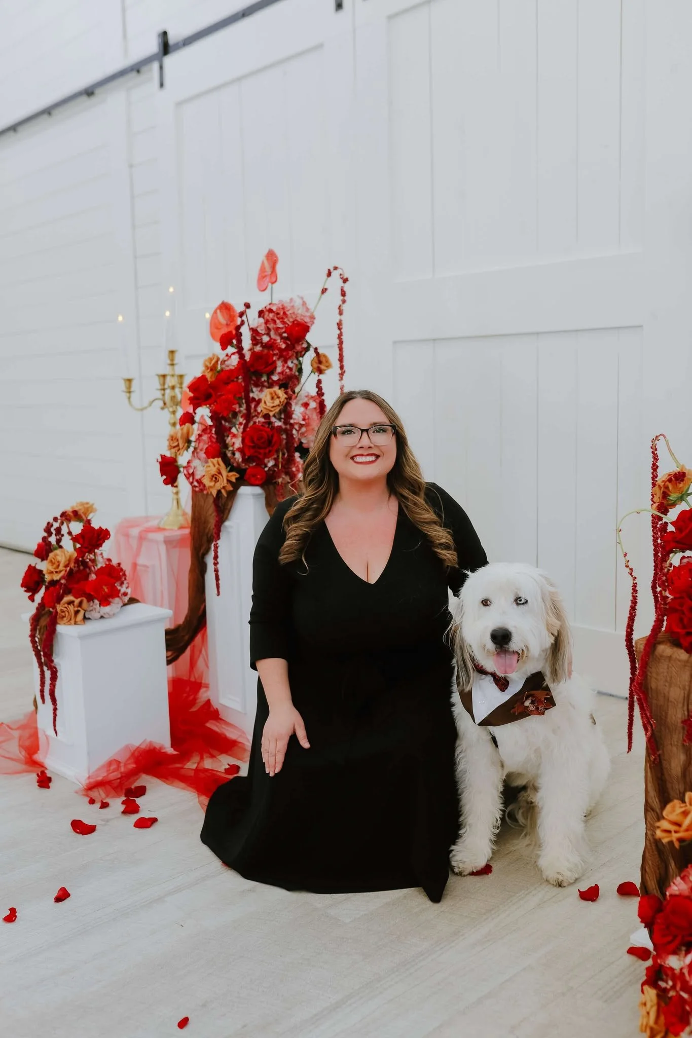 Professional wedding dog attendants from Wags of Love posing with dog of honor in front of ceremony site.
