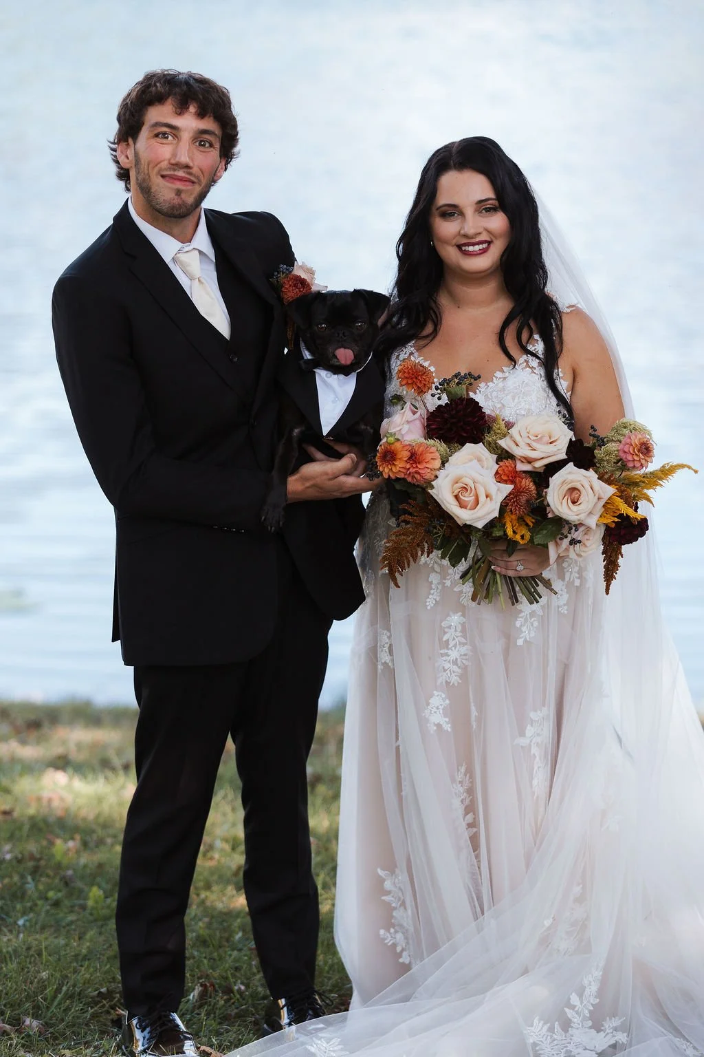 Bride and Groom holding dog while smiling at Milwaukee wedding with Wags of Love team