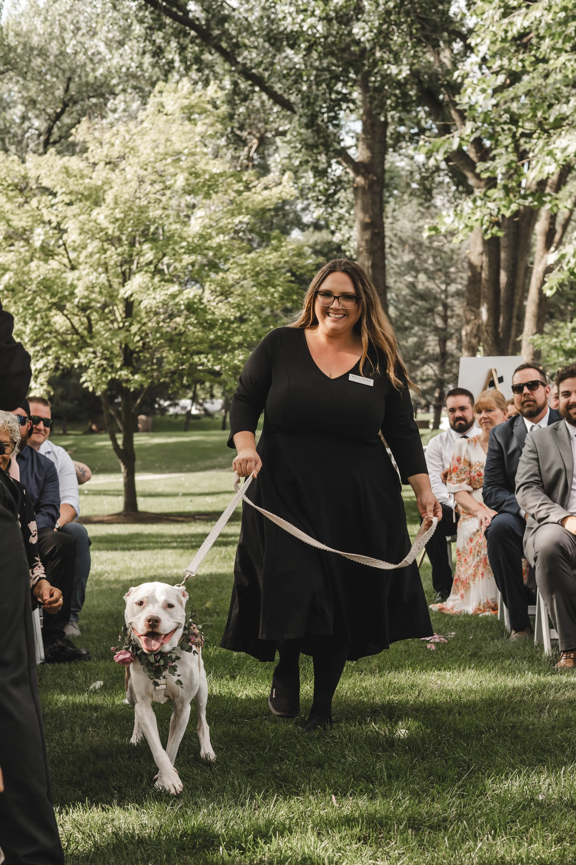 Professional pet wedding attendant Wags of Love walking dog down aisle at ceremony.