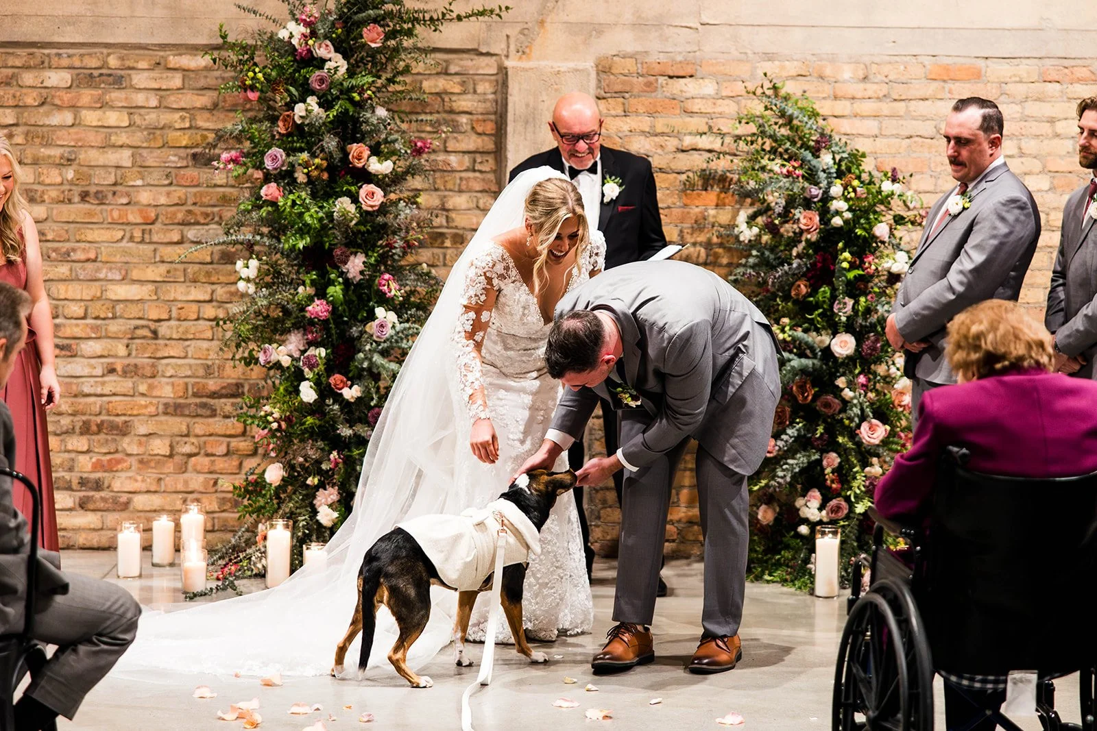 Bride and Groom greeting their flower dog at the front of their ceremony during wedding.