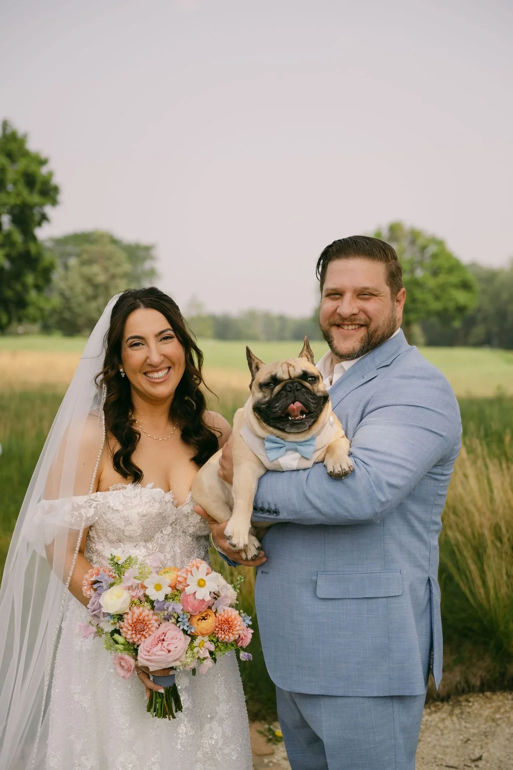 Bride and groom smiling with their dog attended by Wags of Love at Chicago wedding.