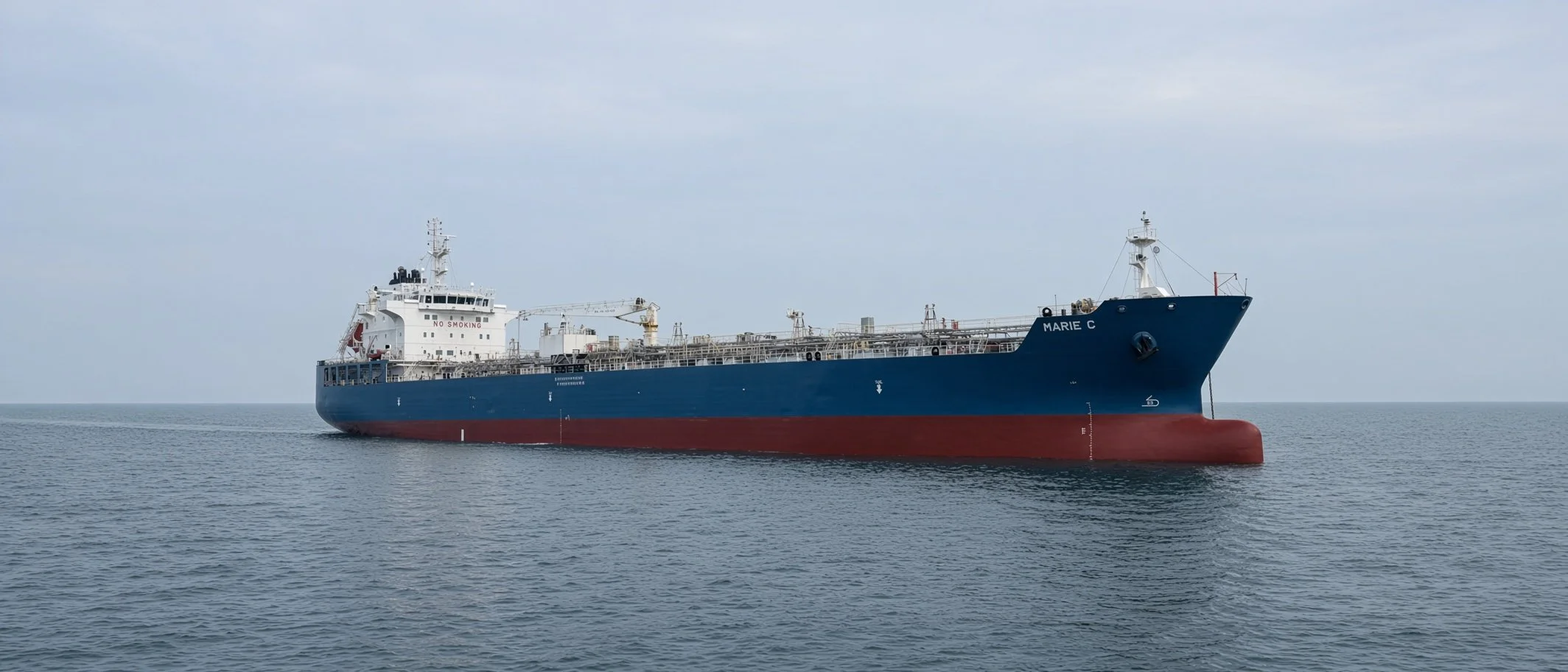 Blue and red oil tanker ship Marie C sailing on calm ocean waters