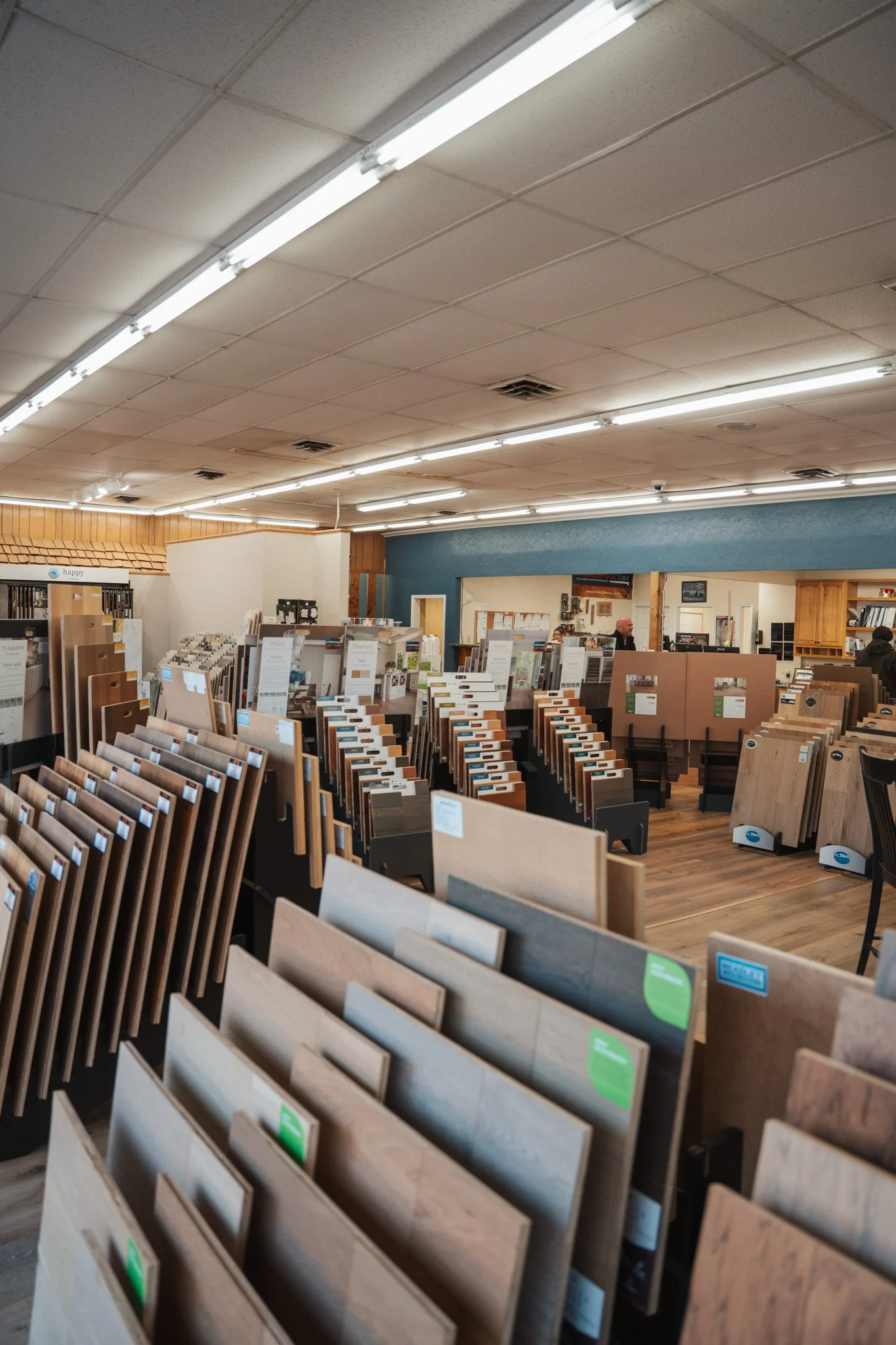 Interior of a flooring store displaying various samples of wood and laminate flooring arranged in rows.