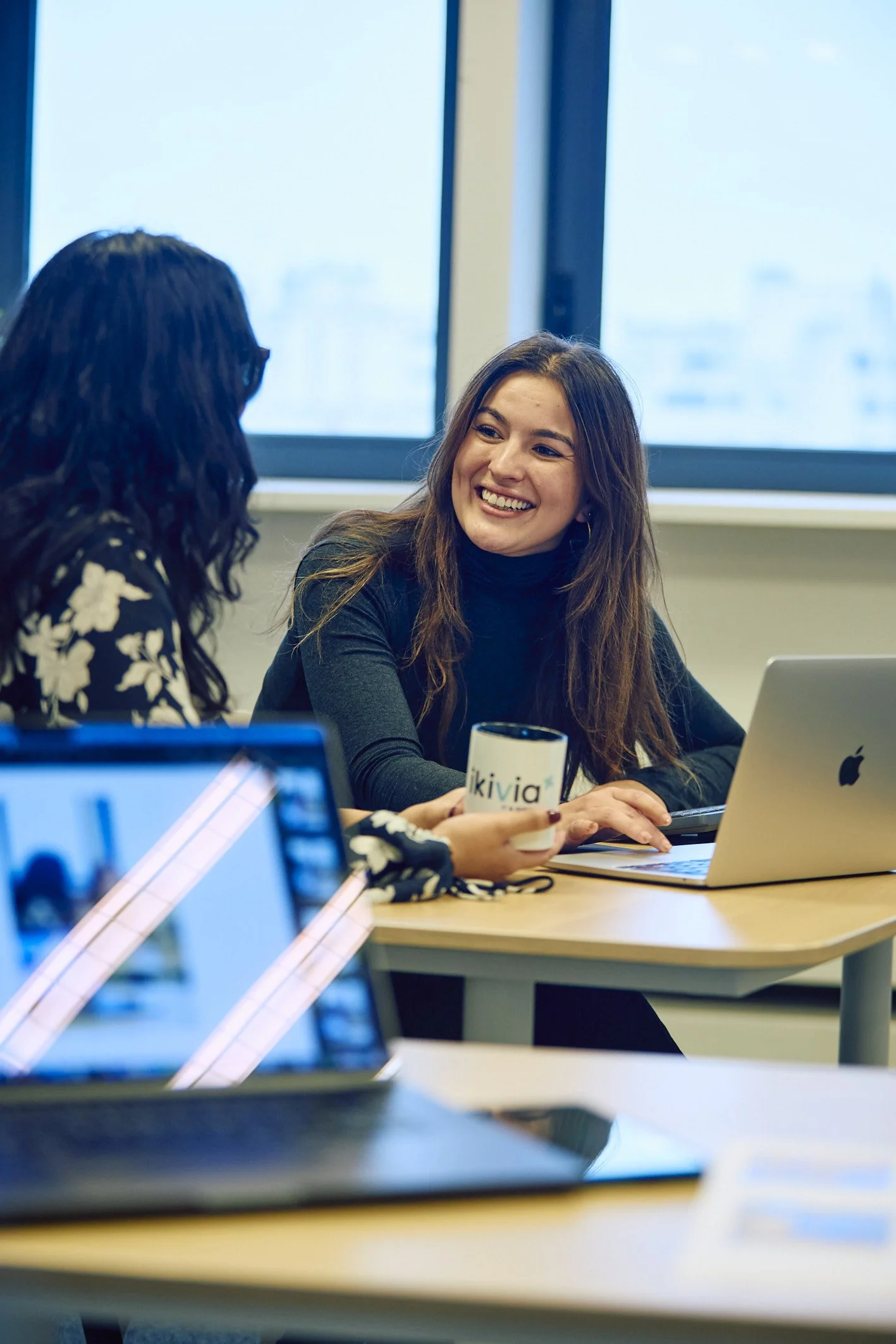 Discussion entre deux collaboratrices dans les bureaux de l'agence de Lille