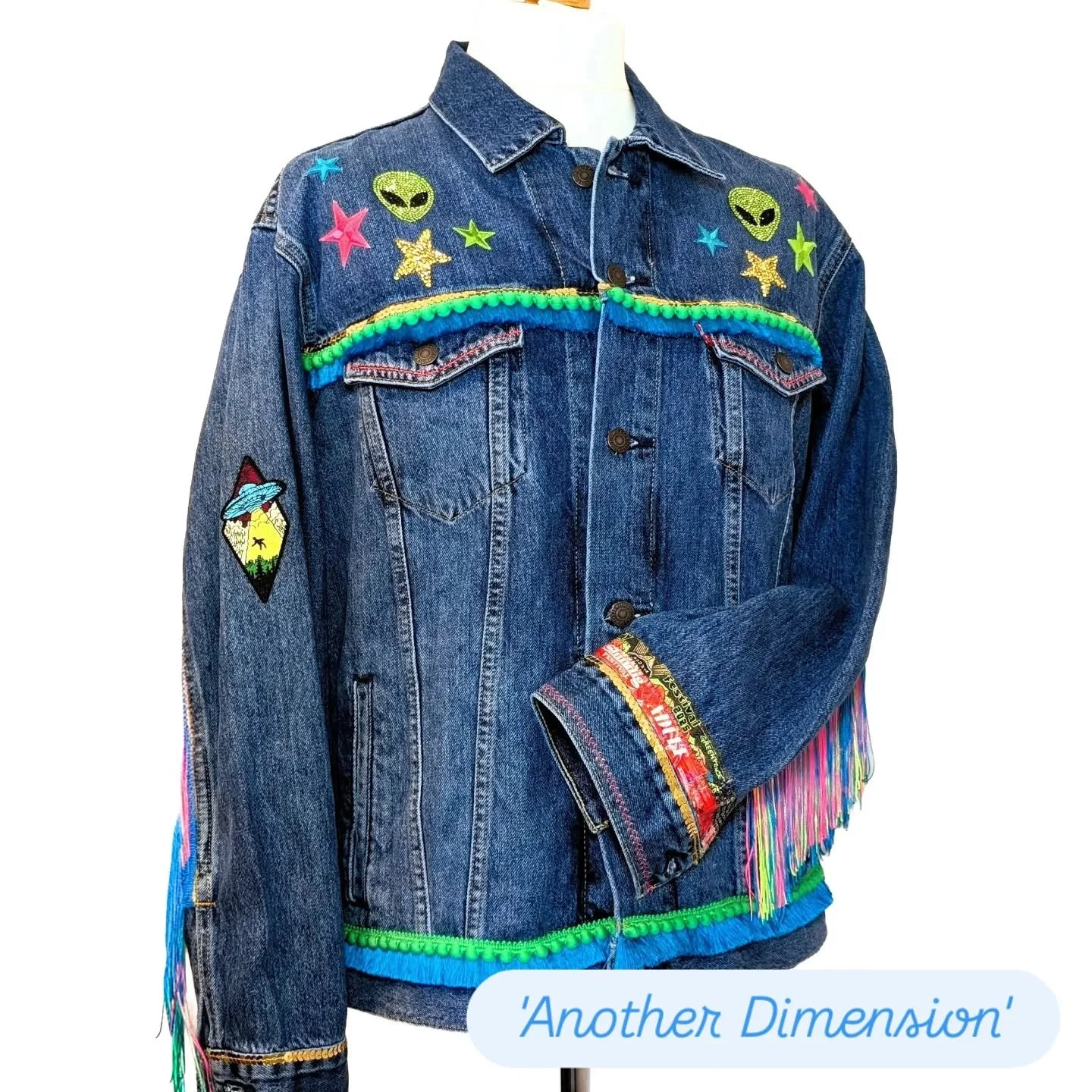 Jacket No. 27: Another Dimension 👽✨

A one-of-a-kind commission for a festival-goer who makes friends wherever they go! Custom event patches that can be swapped as needed: 
SHINDIG, GLASTONBURY &amp; SHAMBALA &mdash; stitched in rhinestones, sequins