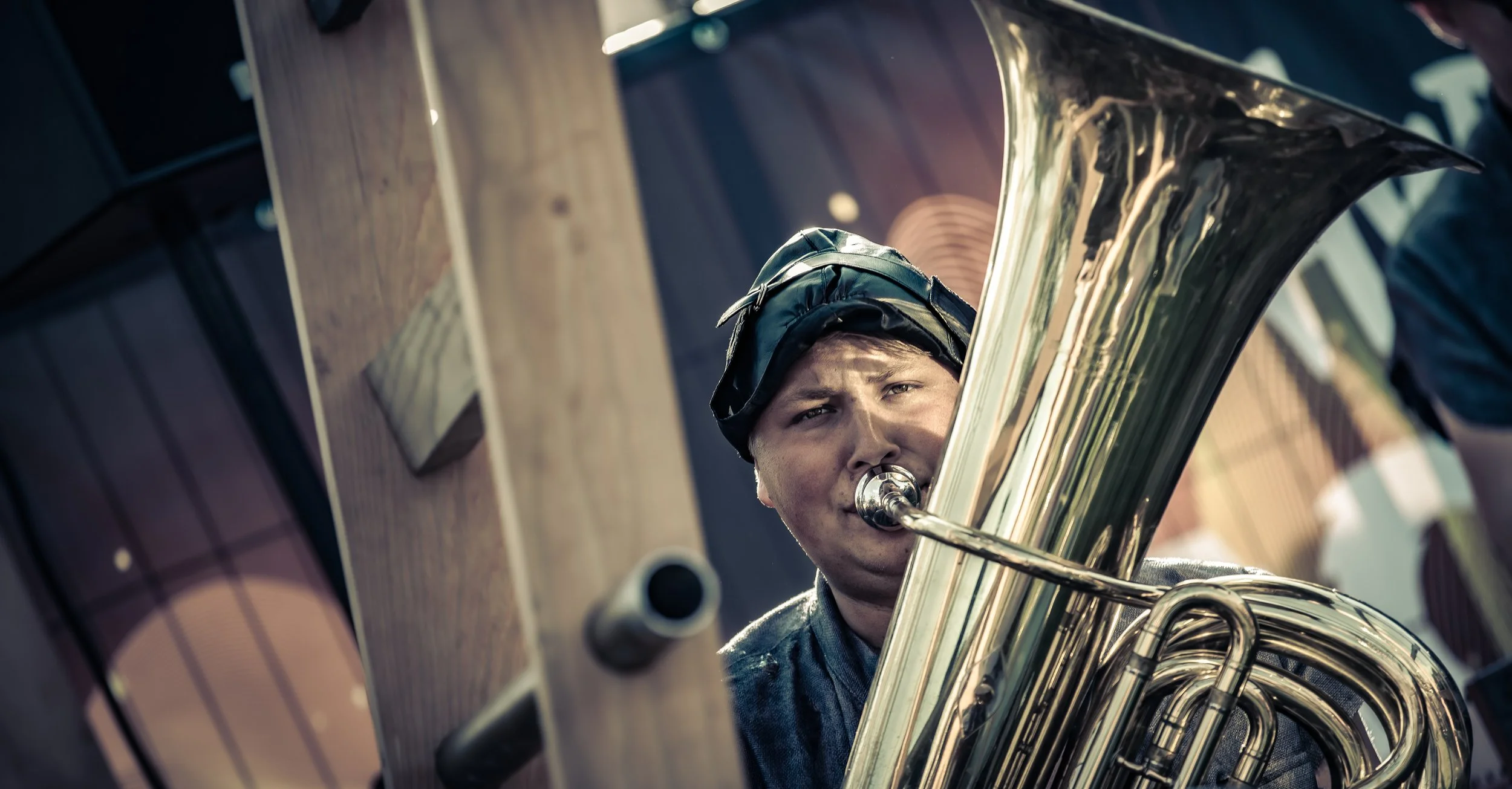 Man speelt een saxofoon, omringd door houten meubels.