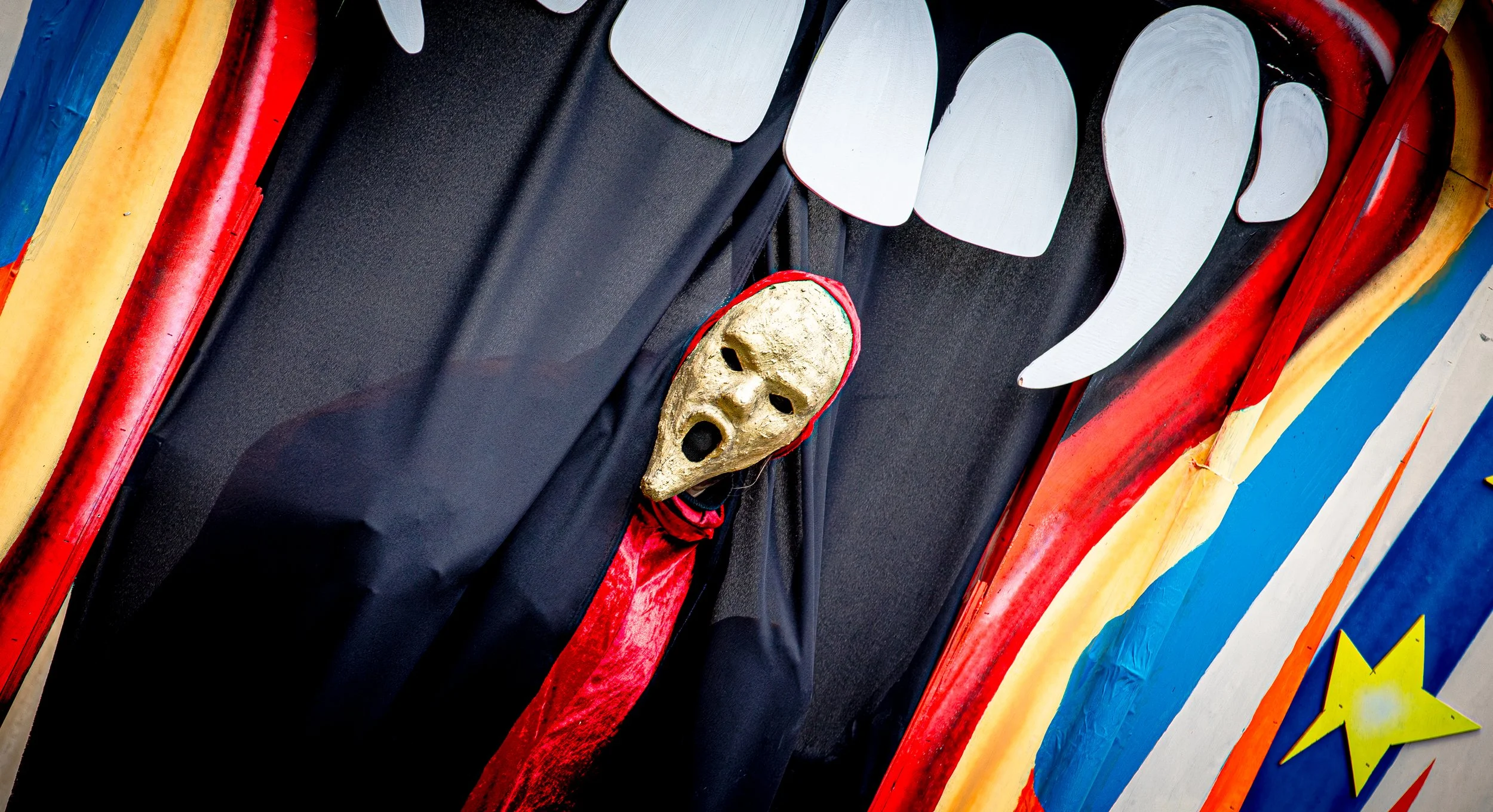 Theatra Obscura - driekoppige vrouw steekt een van haar hoofden door het doek