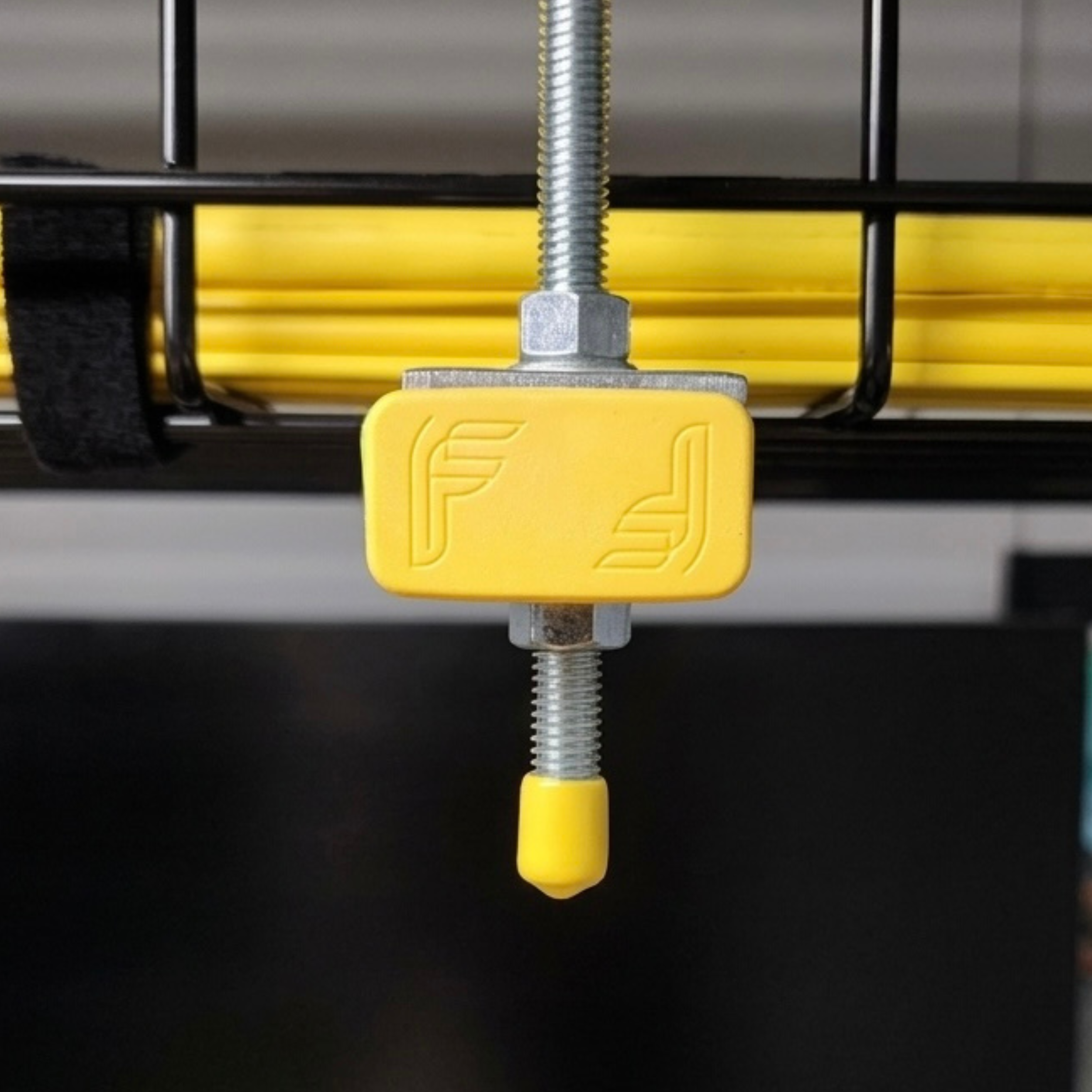 Close-up of a screw, yellow plastic piece, and metallic parts, possibly part of machinery or equipment.