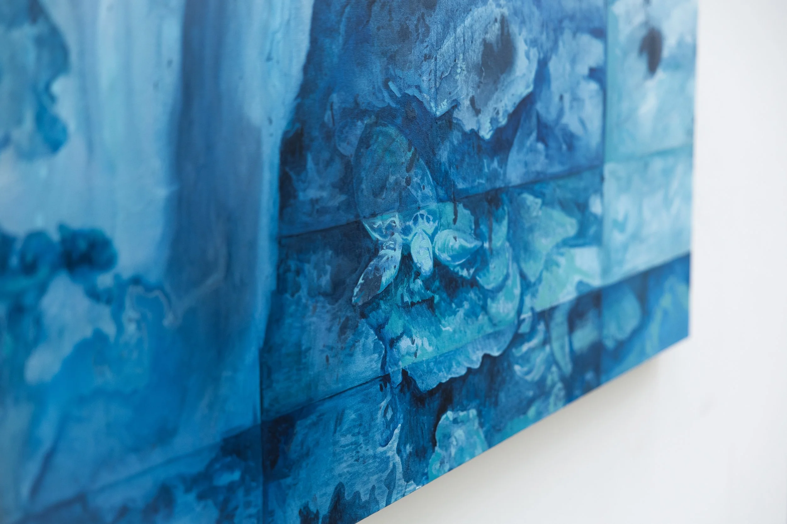 Close-up of a textured blue painting or mural with abstract floral design on a wooden panel