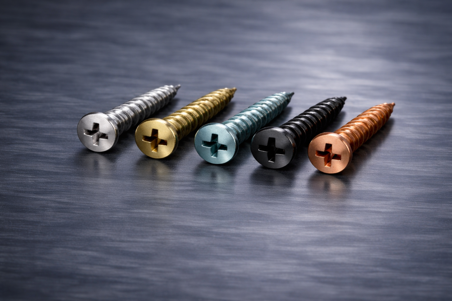 Five colorful screws with flathead slots arranged in a row on a dark surface.