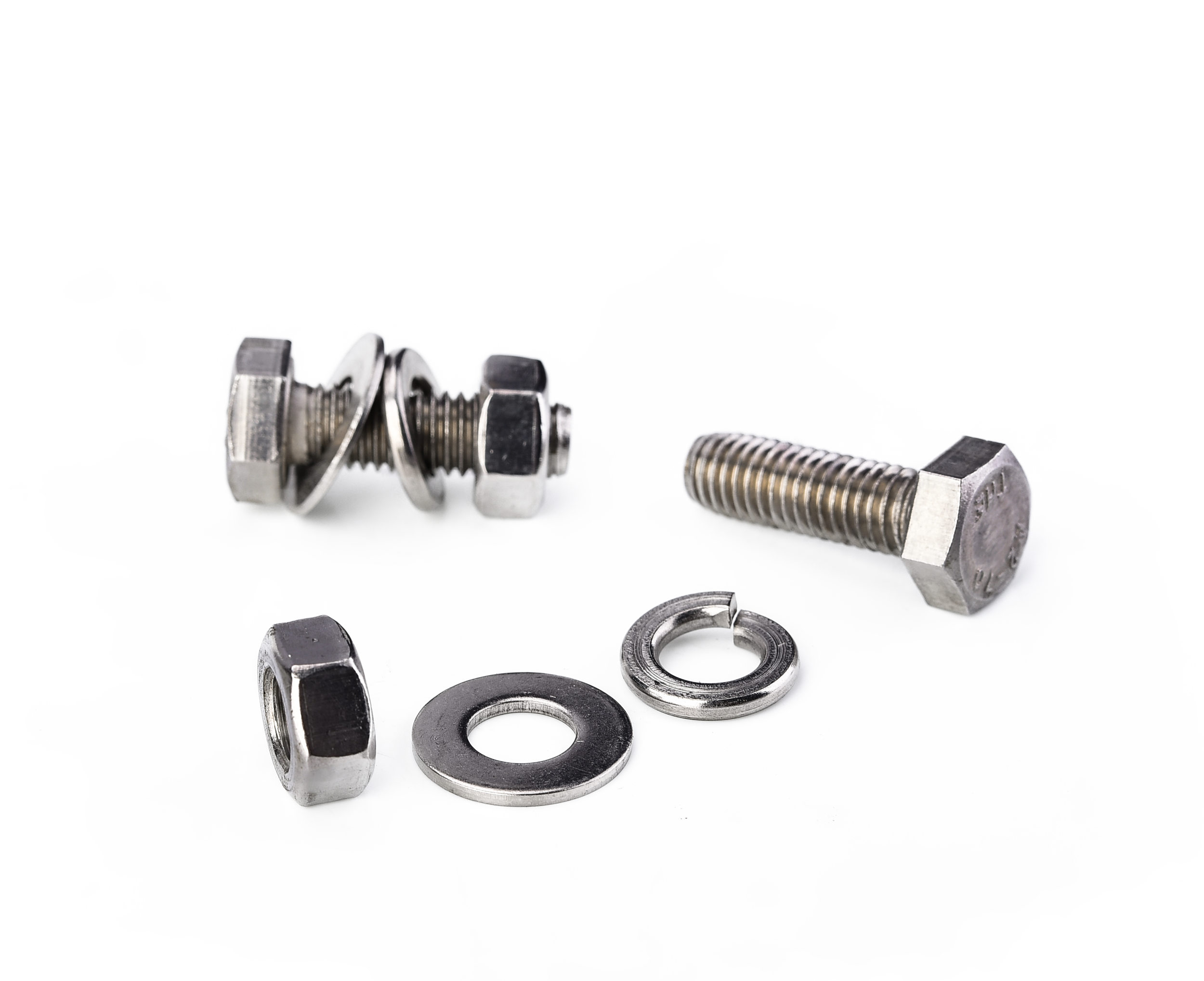 Various metal bolts, washers, and nuts on a white surface.
