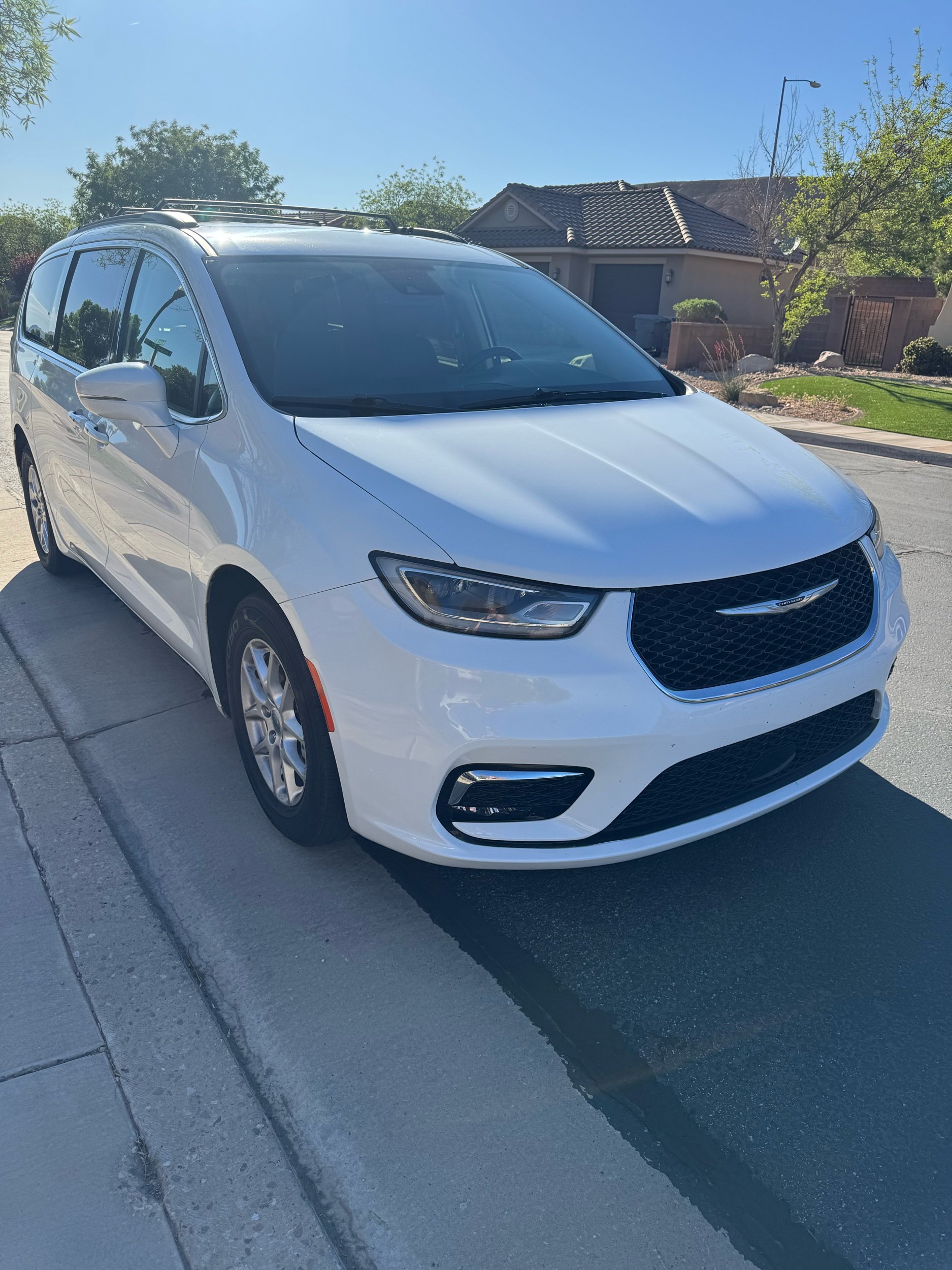 White Chrysler minivan parked on the street in after being delivered for a rental