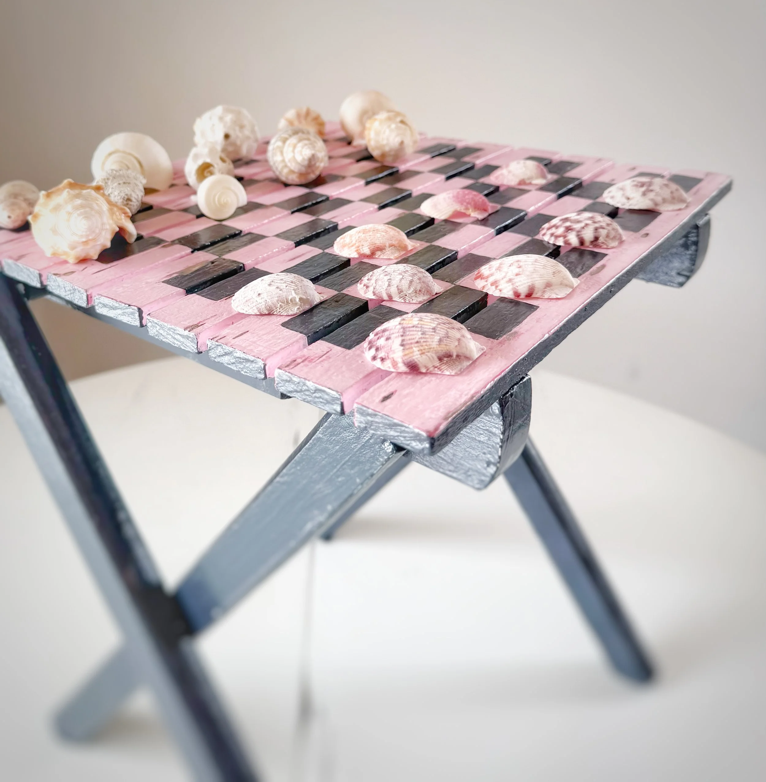 Upcycled wooden garden table, hand painted and paired with sea treasures to create a chess set.