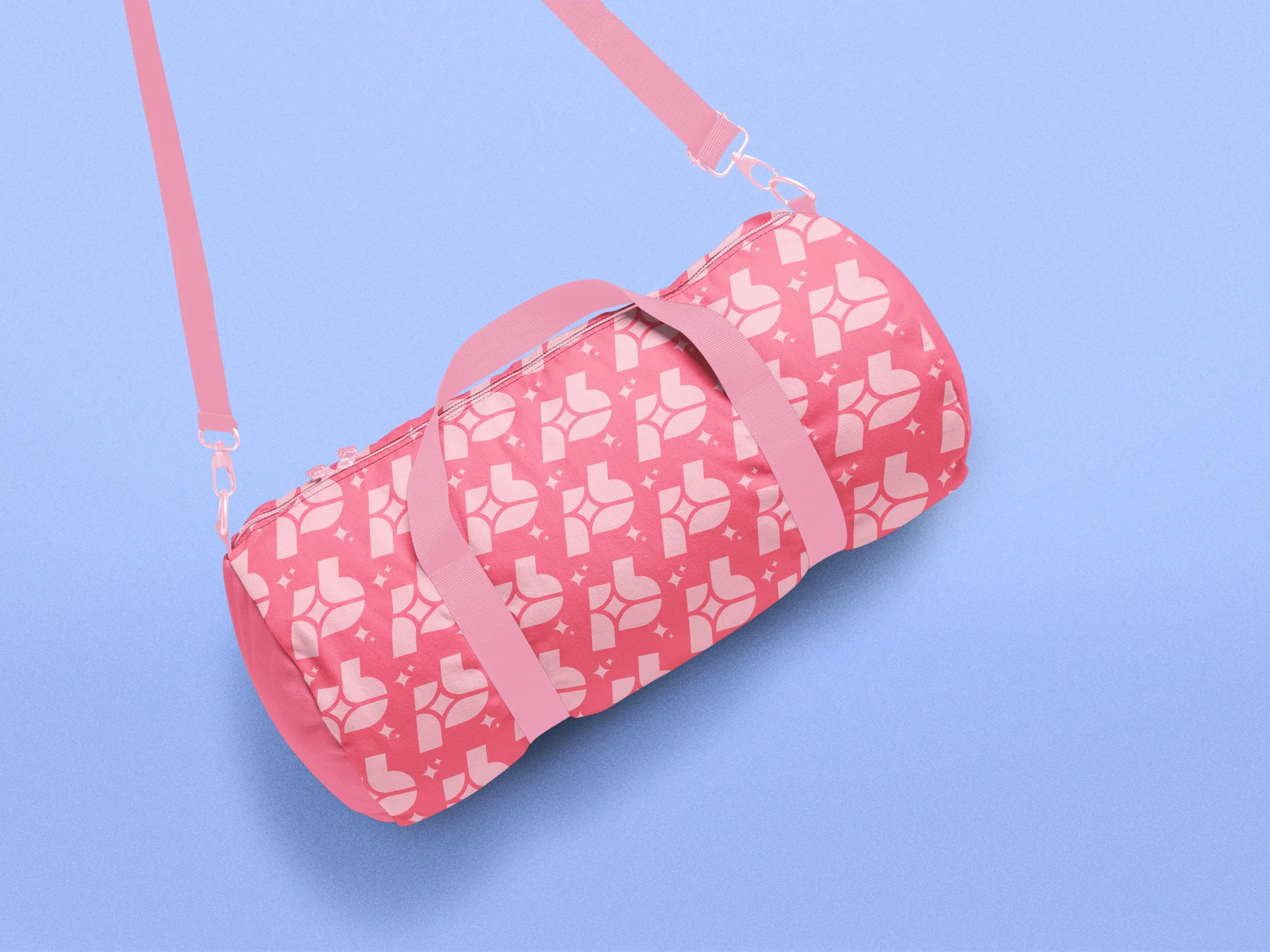Pink duffel bag with white geometric pattern on a light blue background.