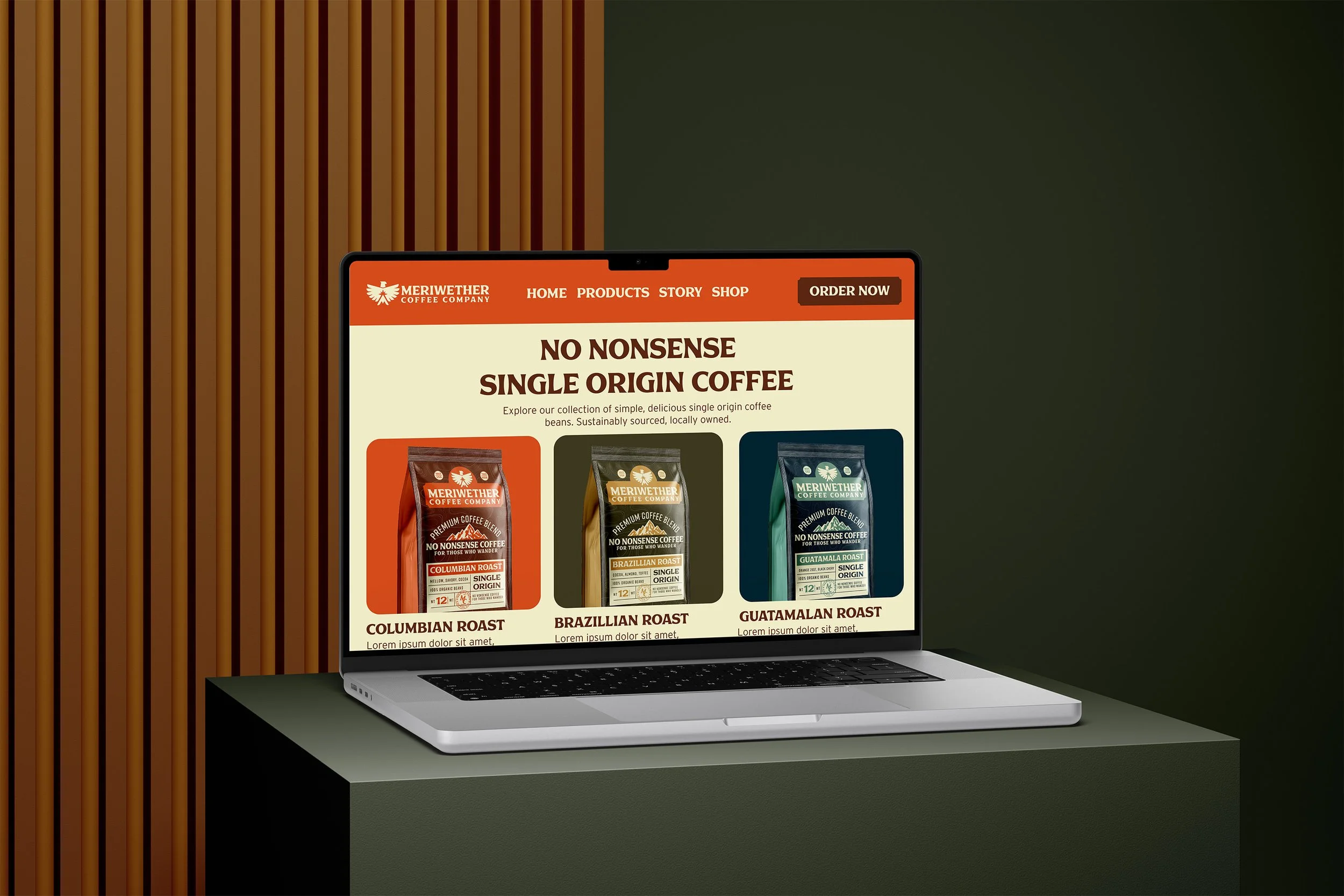Laptop on a green table displaying a website for Meriwether Coffee Company, featuring single origin coffee bags in Columbian, Brazilian, and Guatemalan varieties.