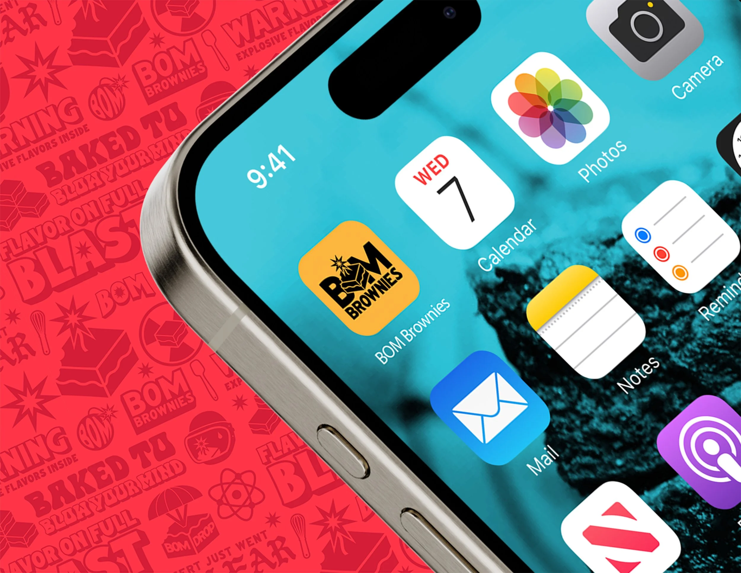 Close-up of a smartphone screen showing app icons on the home screen, including BOM Brownies, Calendar, Photos, Mail, Reminder, Notes, and Camera. The time displayed is 9:41, and the date is Wednesday the 7th. Part of the phone's metal edge and a red
