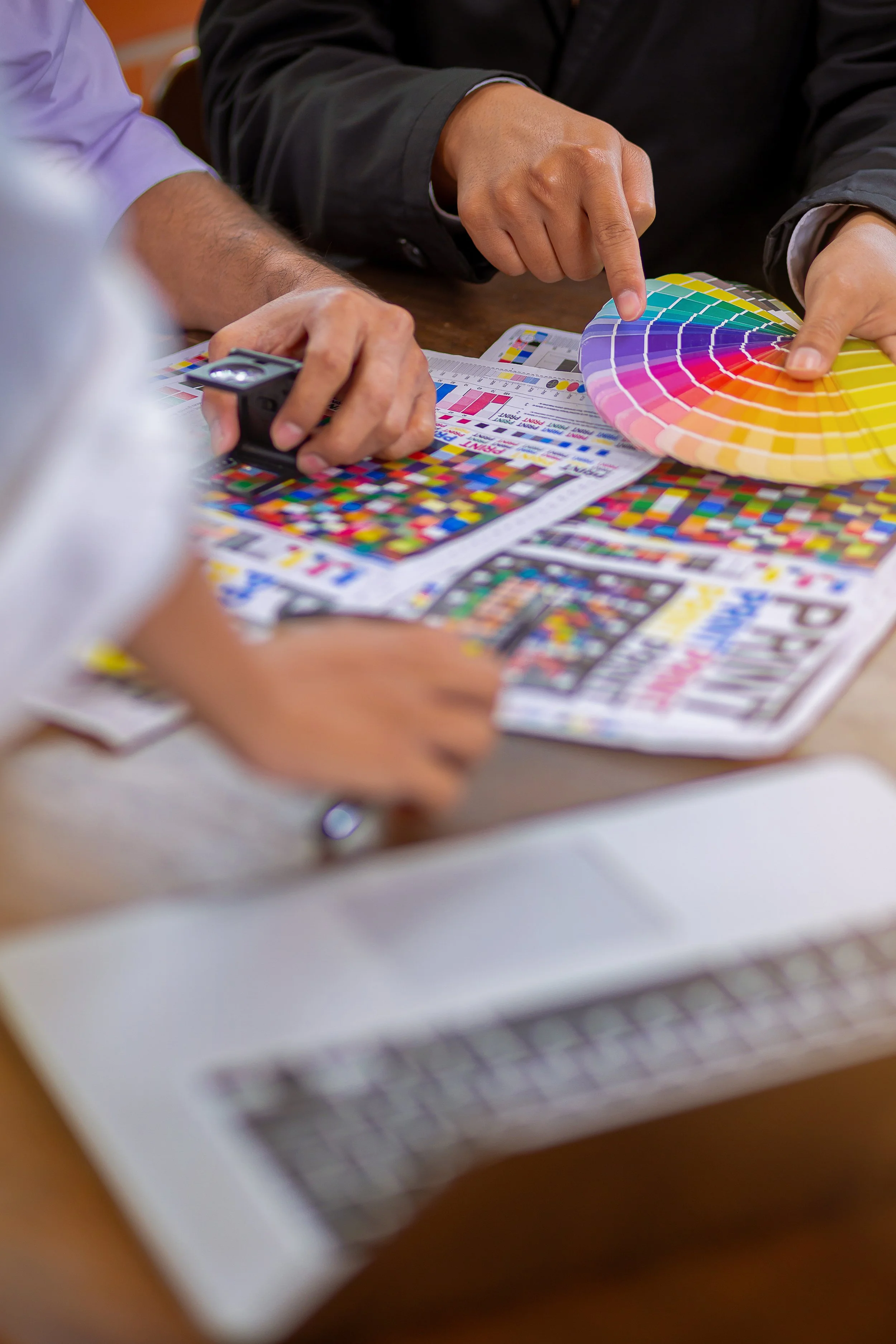 People discussing color palettes and color swatches at a design table.