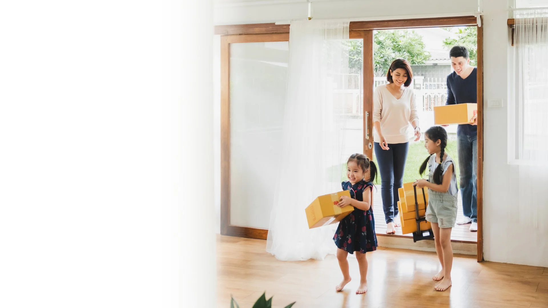 Family entering home with moving boxes