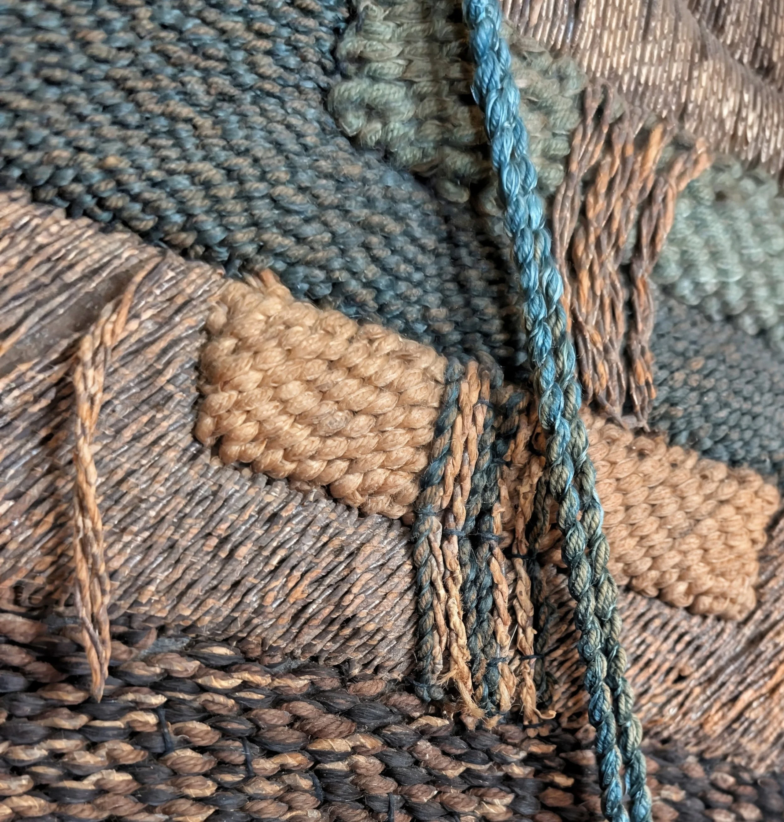 Close-up of a woven textile fabric with a blue braided cord.  China or Japan.