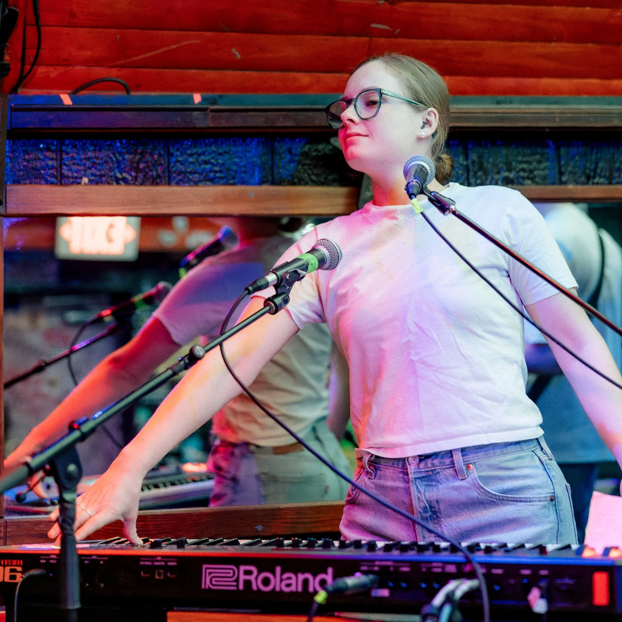 Lydia Blair performs live on stage playing her Roland Fantom 06 keyboard.