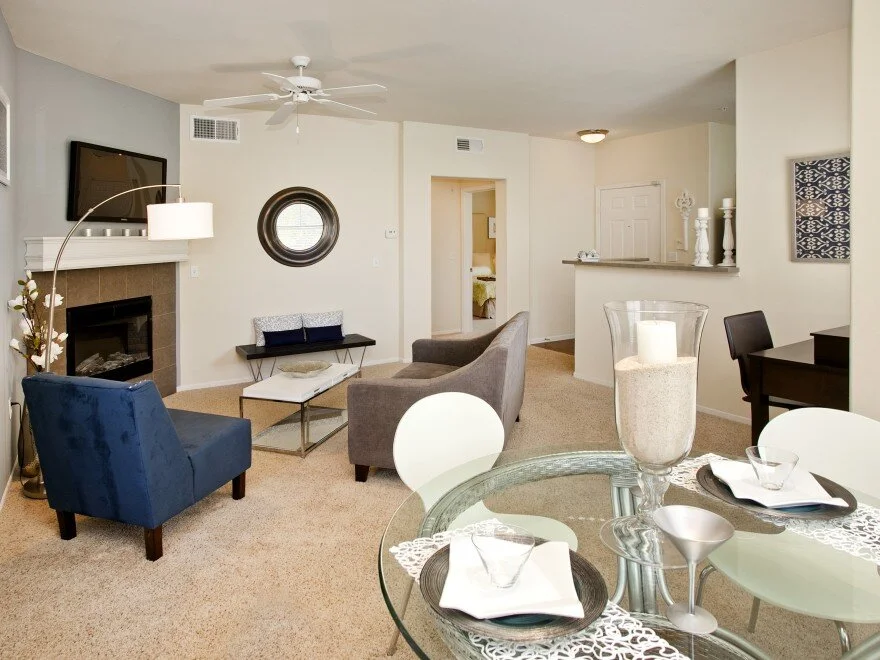 Living/Dining area inside apartment at The Overlook at Rancho Belago with carpeted flooring, cream walls, and a fireplace