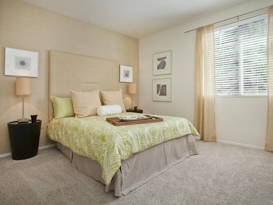 Bedroom in apartment at The Overlook at Rancho Belago with carpeted flooring, cream walls, one beige accent wall, and large window