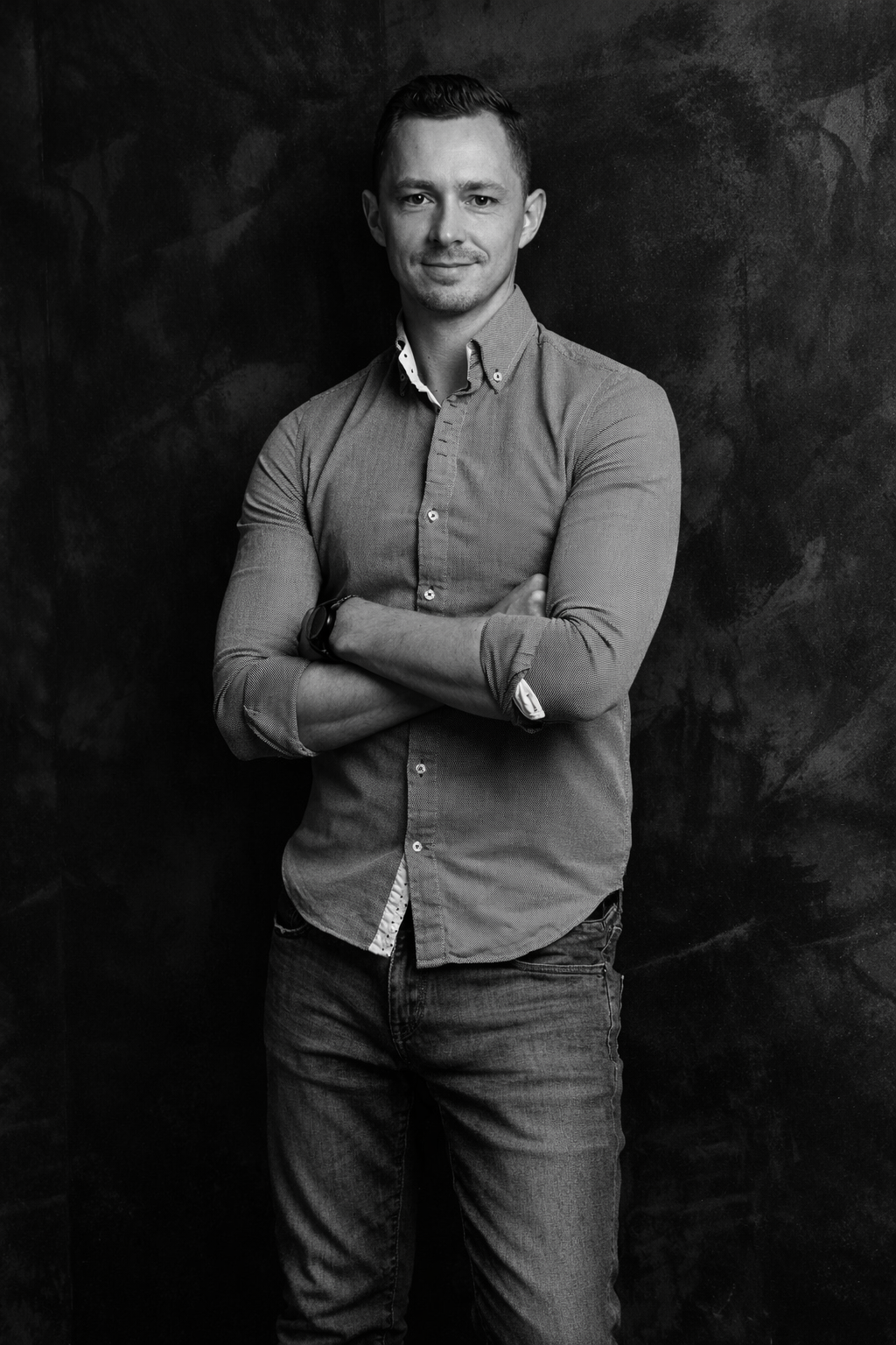 Sportlicher, junger Mann steht mit verschränkten Armen vor einer dunklen Wand und strahlt Zuversicht und Sicherheit aus. #Selbstverteidigung #Selbstbestimmung #defendyou #selfdefense #selbstbestimmung #sicherheit #selbstverteidigungfürfrauen