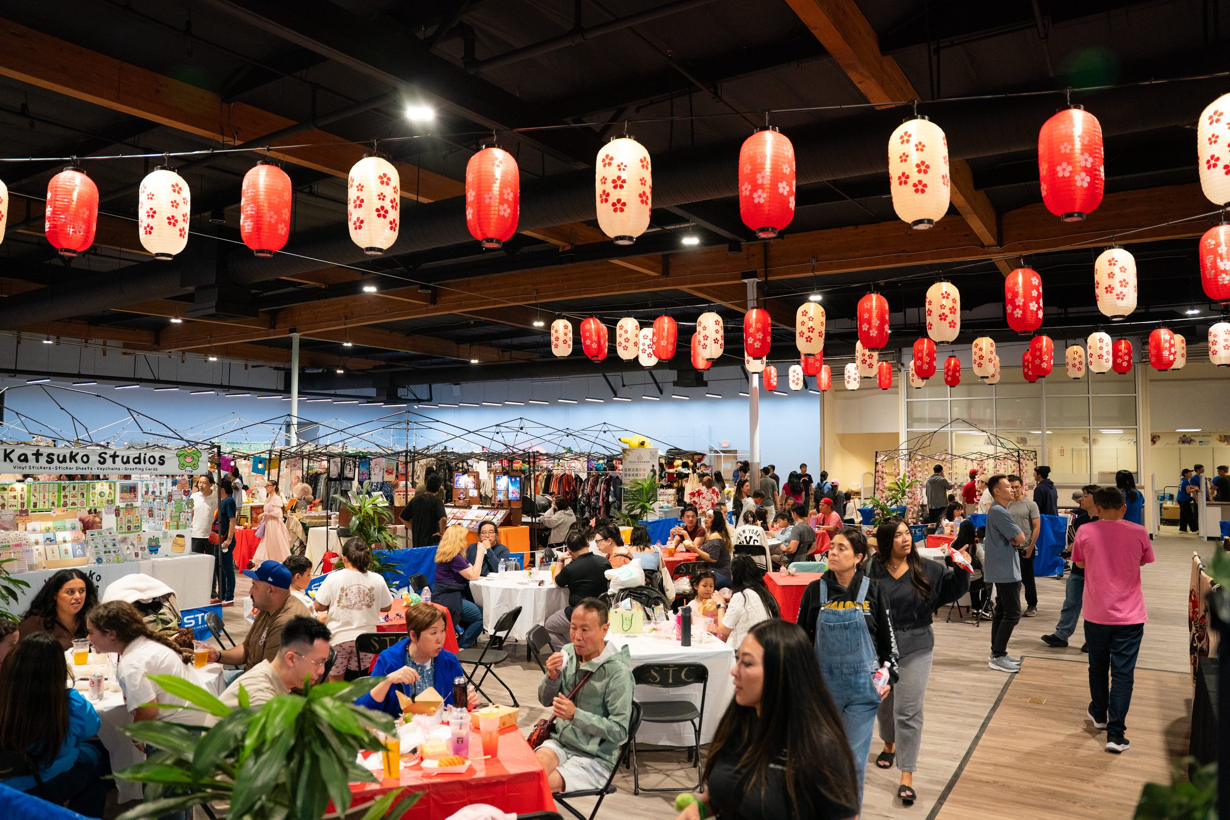 The indoor venue area at STC Rowland Legacy. Takumi Alley's Midnight Konbini of artists and makers on one side and the Matsuri Izakaya on the other, serving fresh sashimi and Japanese and Taiwanese beer and sake. Gorgeous colorful lanterns are strung