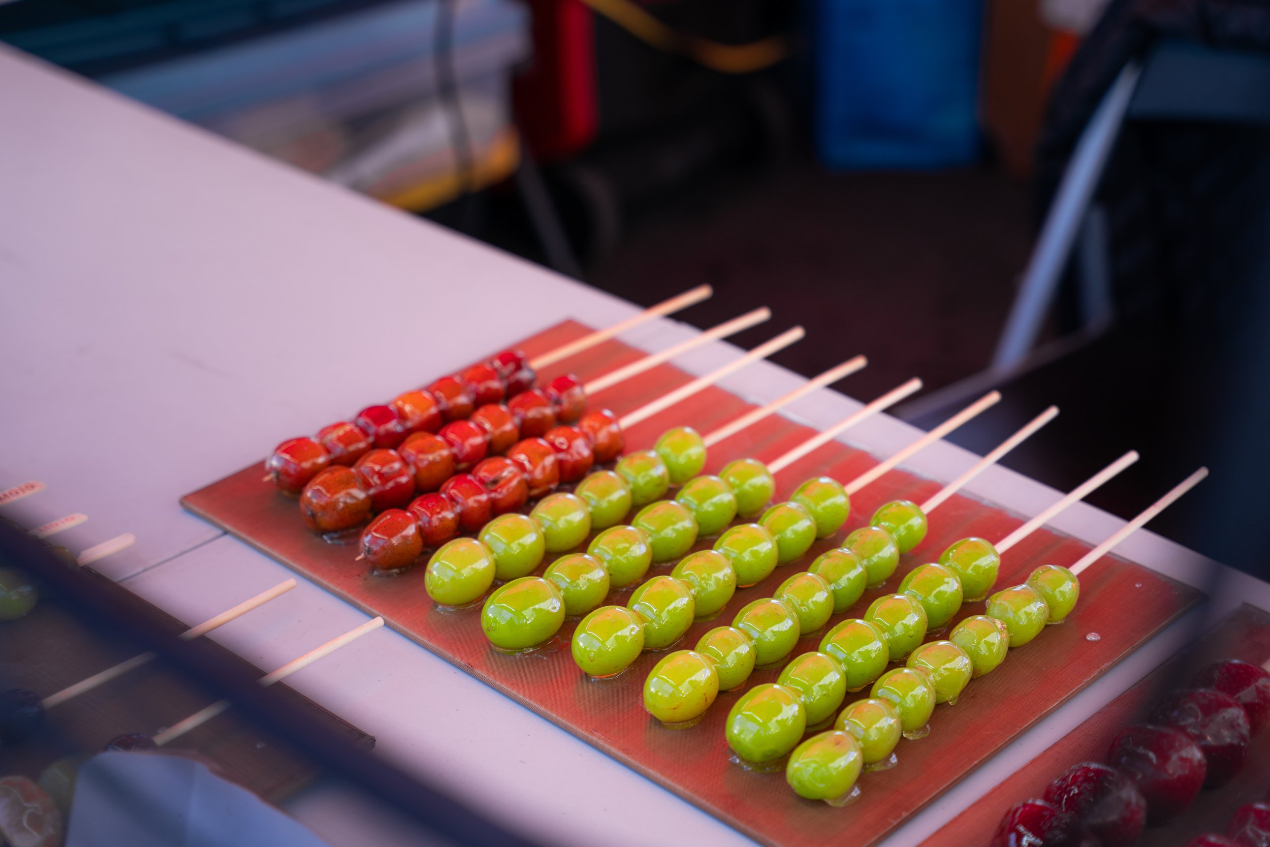 candied fruit or tanghulus on a table. candied fruit or tanghulu on a stick at the night market