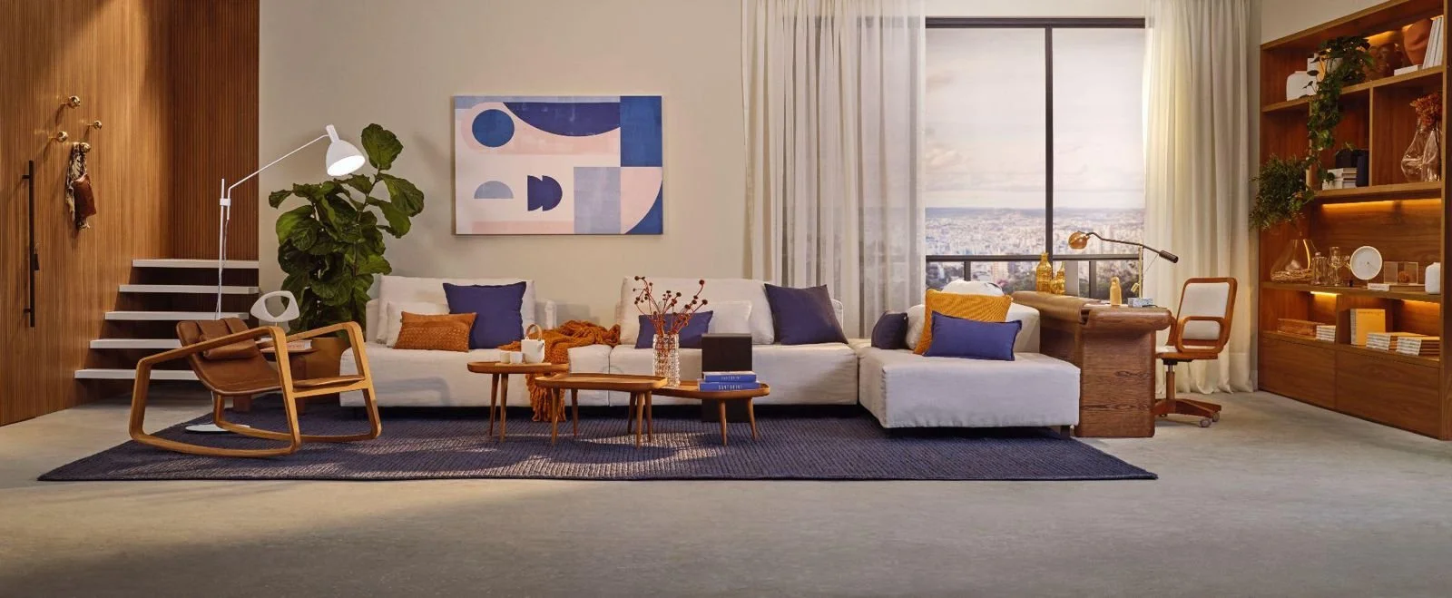 Sala de estar com sofá branco, almofadas roxas e amarelas, mesa de centro de madeira, cadeira de balanço de madeira, estante de madeira com livros e objetos decorativos, estante com iluminação, quadro abstrato azul e rosa na parede, planta grande, ja