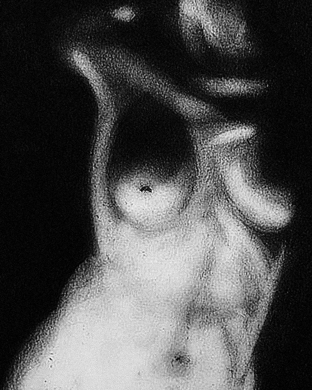 Fotografia em preto e branco de uma pessoa de corpo nu, cobrindo o rosto com uma mão, no estilo artístico com efeito de granulação.