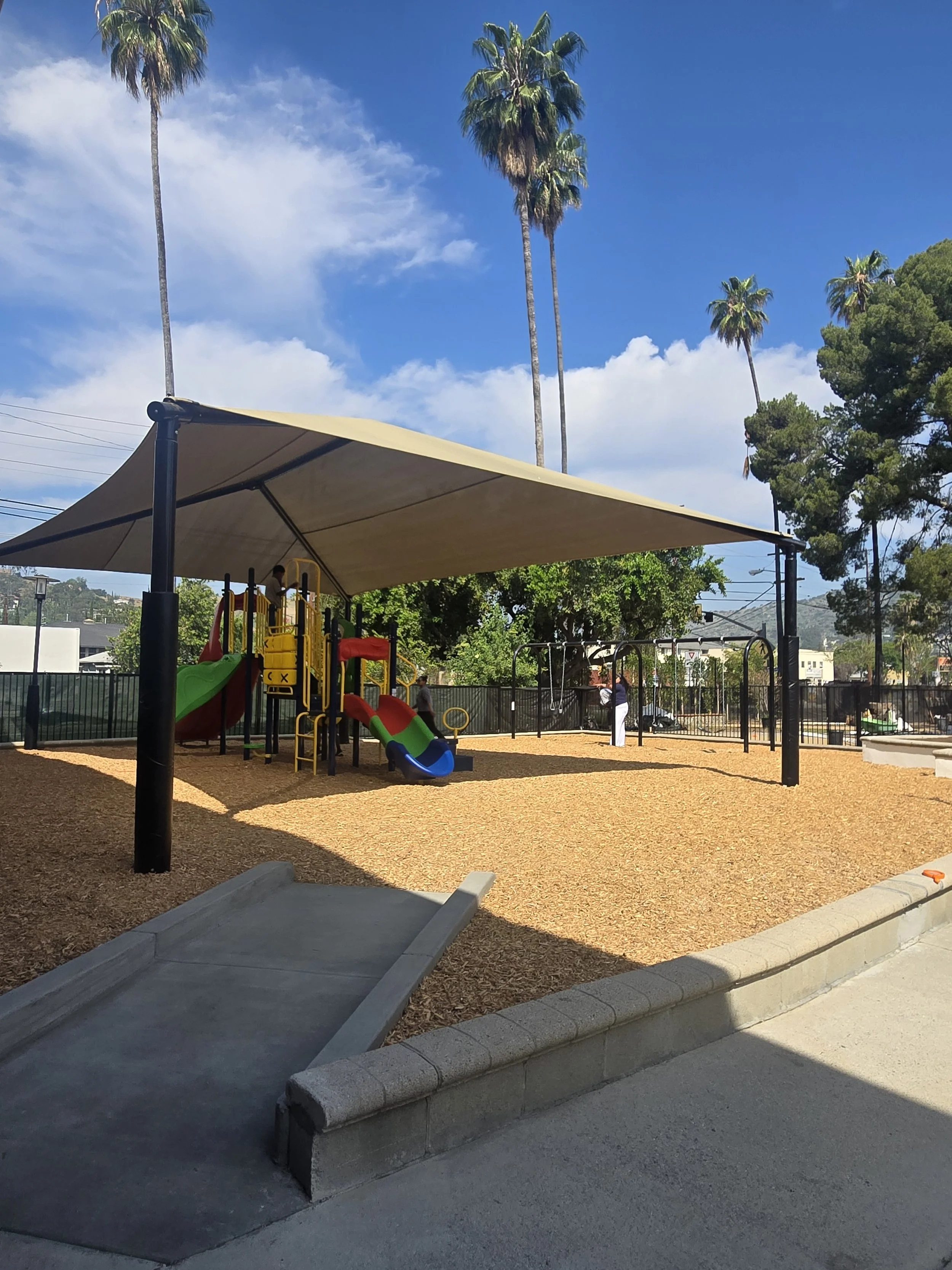 Wooden playground in front of green trees