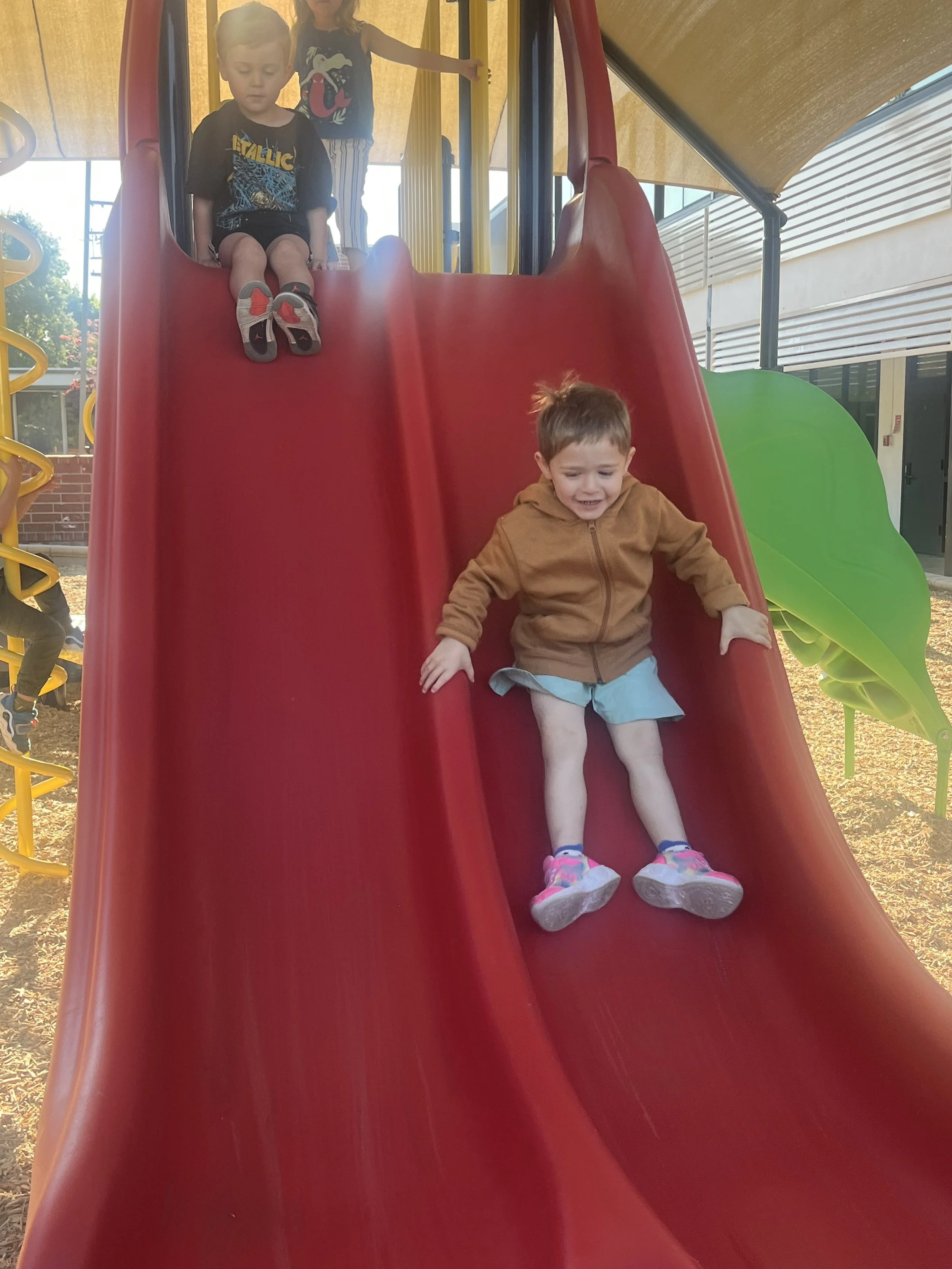 Child with teacher and parent looking at an iPad.
